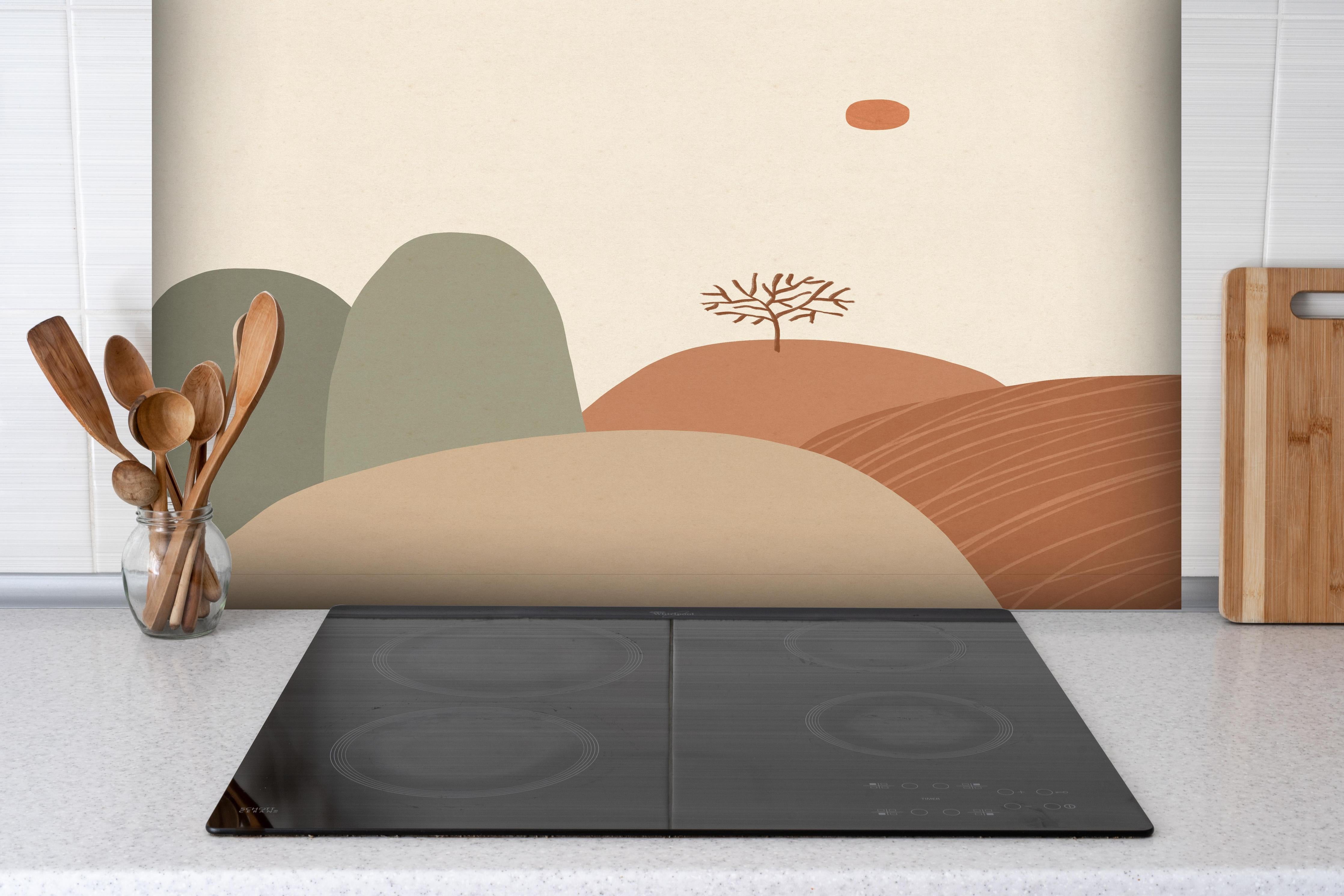 Spritzschutz - Abstrakter Baum, Berge und Herbstsonne hinter einem Cerankochfeld zwischen Holz-Kochutensilien
