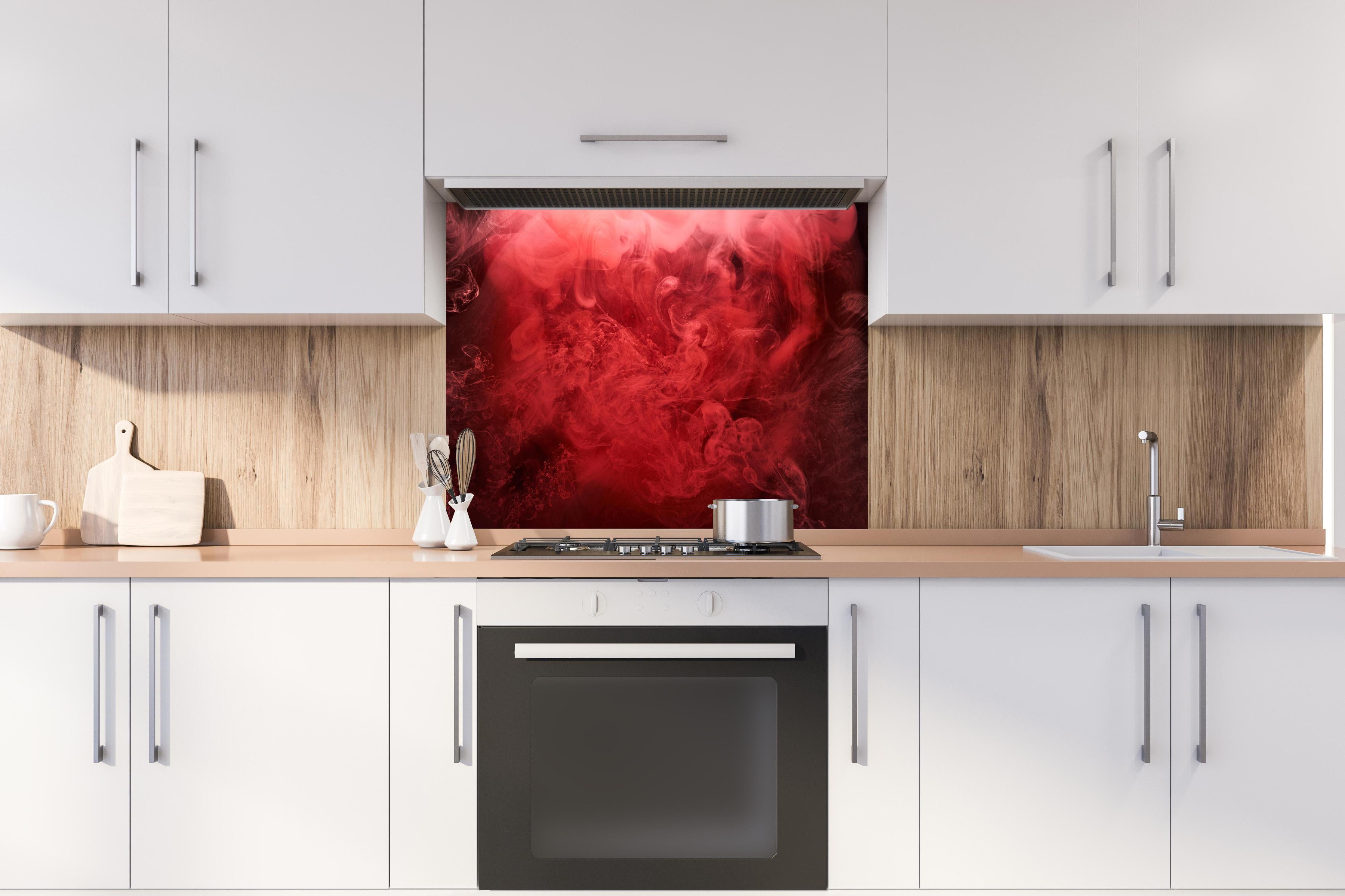 Spritzschutz - Abstrakter roter Ozean hinter einem Cerankochfeld zwischen Holz-Kochutensilien

