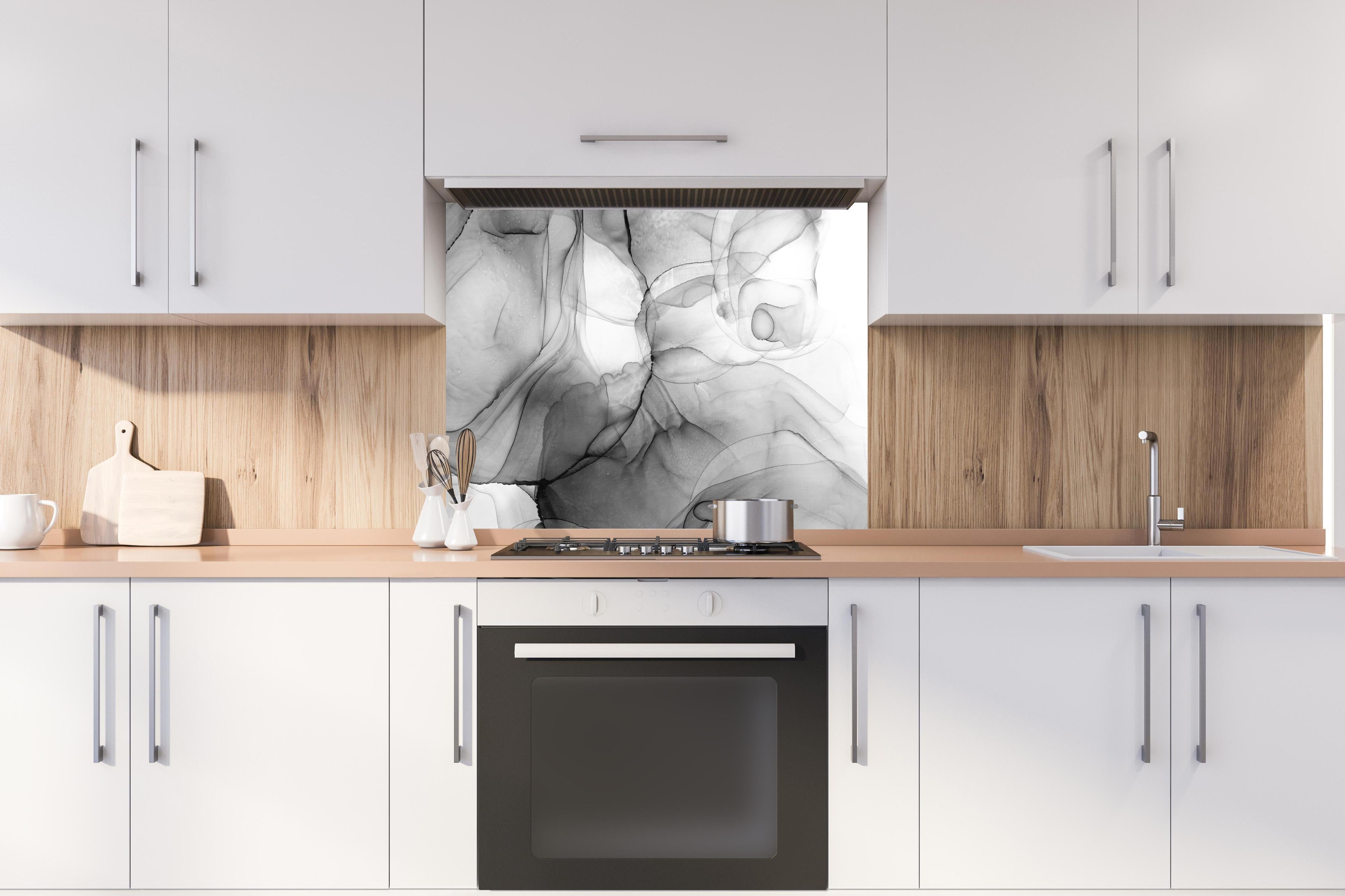 Spritzschutz - Abstraktes Marmor Tinten Design hinter einem Cerankochfeld zwischen Holz-Kochutensilien
