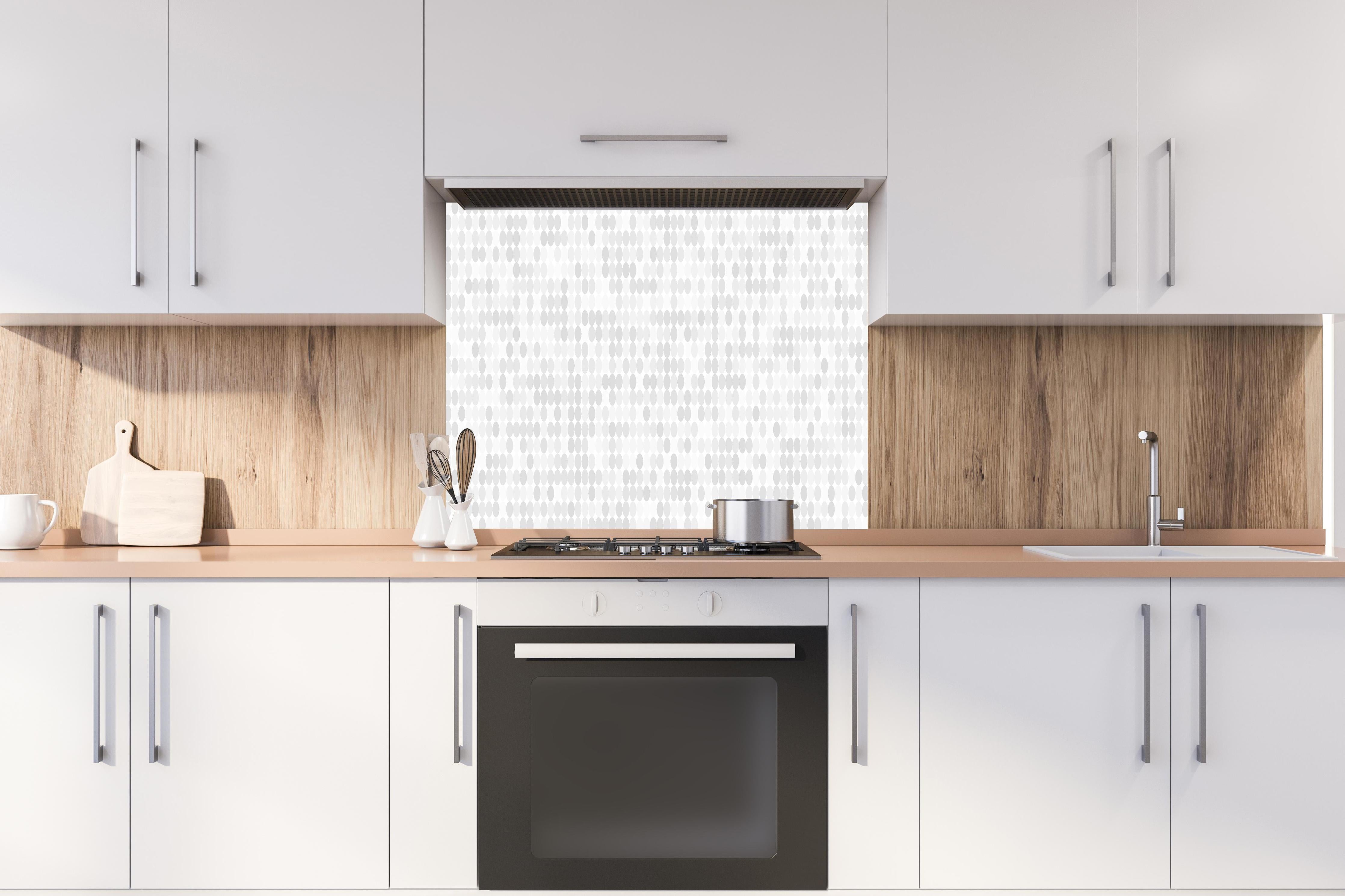 Spritzschutz - Abstraktes Weiß zu Grau Farbverlauf Muster hinter einem Cerankochfeld zwischen Holz-Kochutensilien
