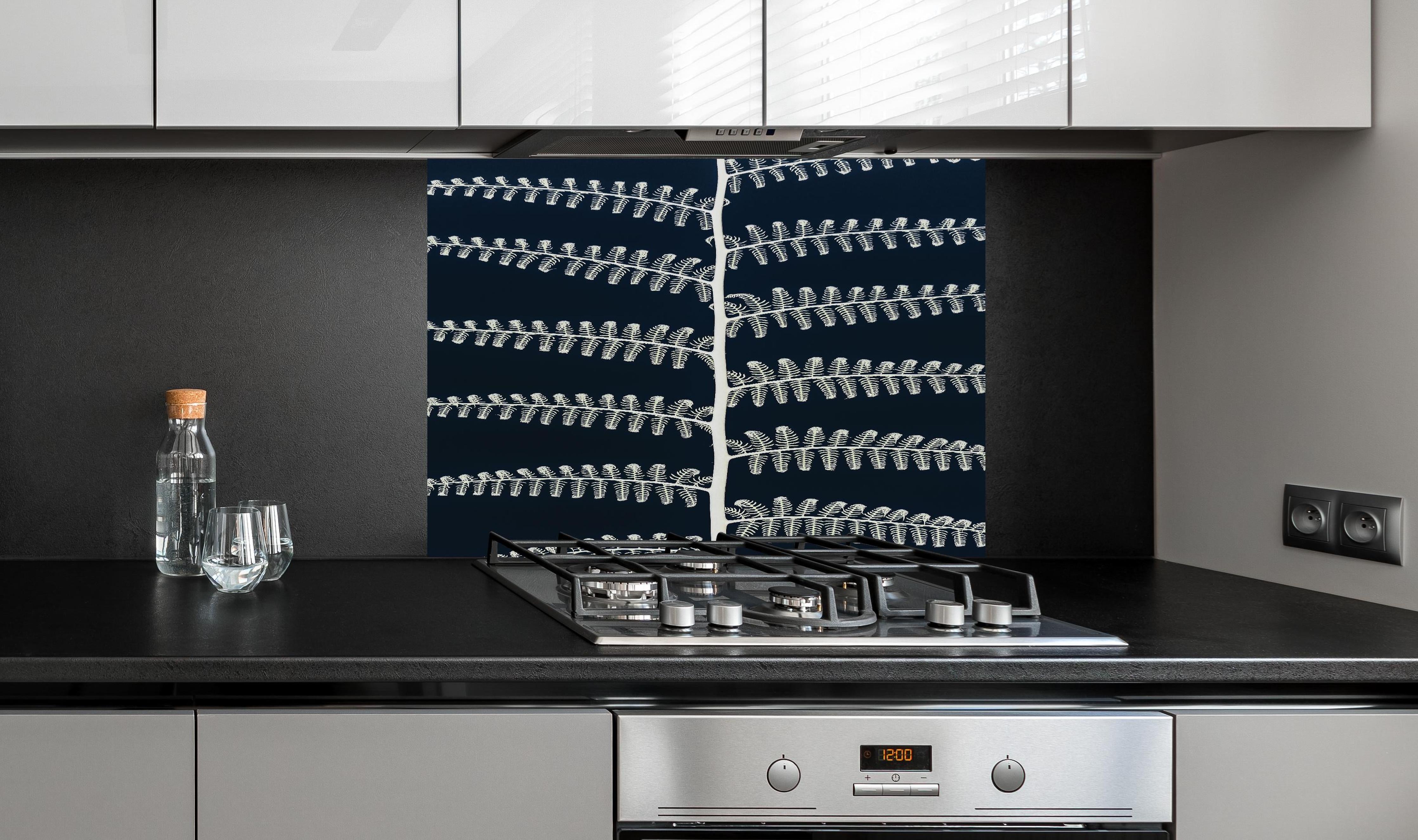 Spritzschutz - Abstraktes symmetrisches Blatt Design in Blau hinter einem Cerankochfeld zwischen Holz-Kochutensilien
