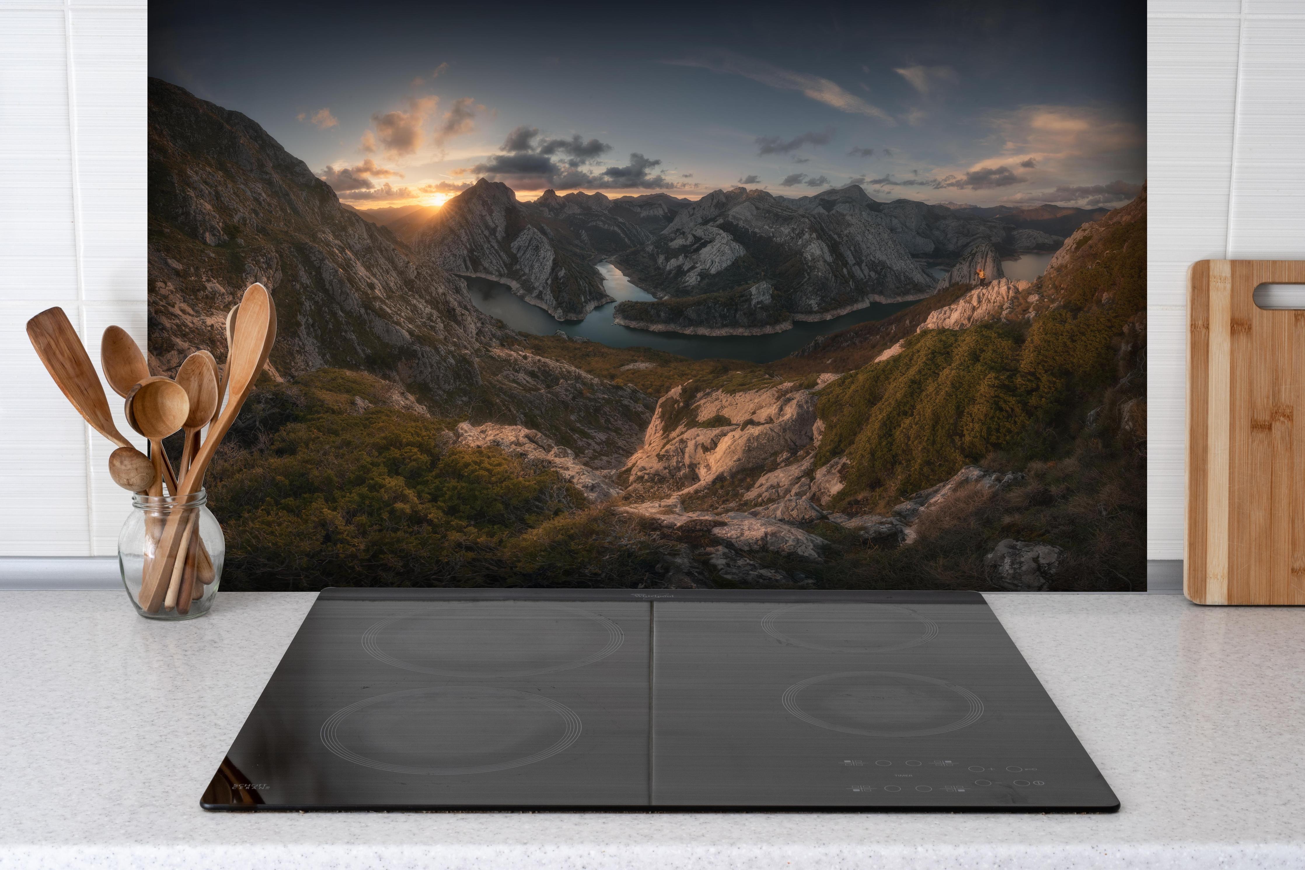 Spritzschutz - Alpenglühen Bergspiegelung Wolkenpanorama hinter einem Cerankochfeld zwischen Holz-Kochutensilien
