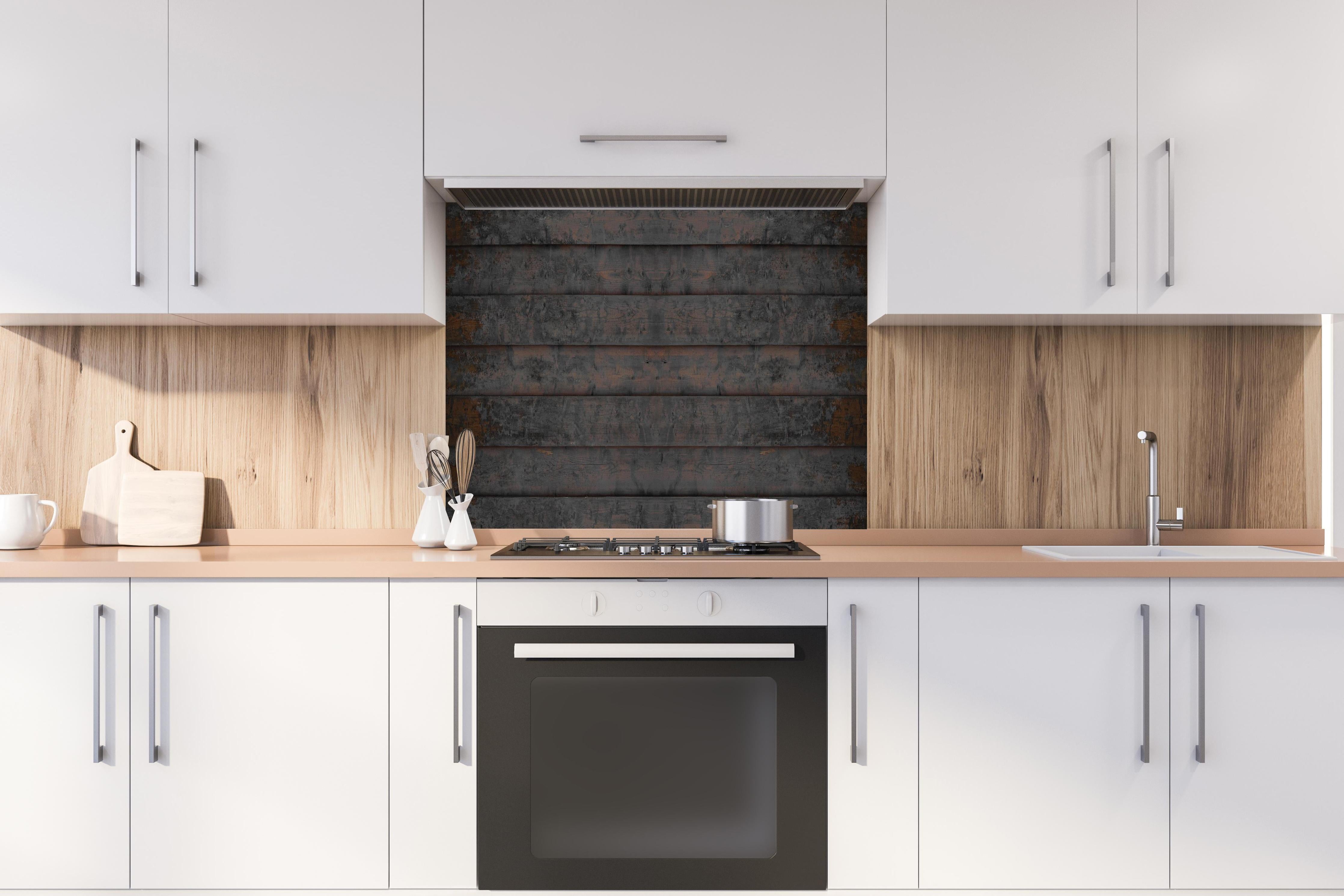 Spritzschutz - Alt braun lackierte Holzbretter hinter einem Cerankochfeld zwischen Holz-Kochutensilien
