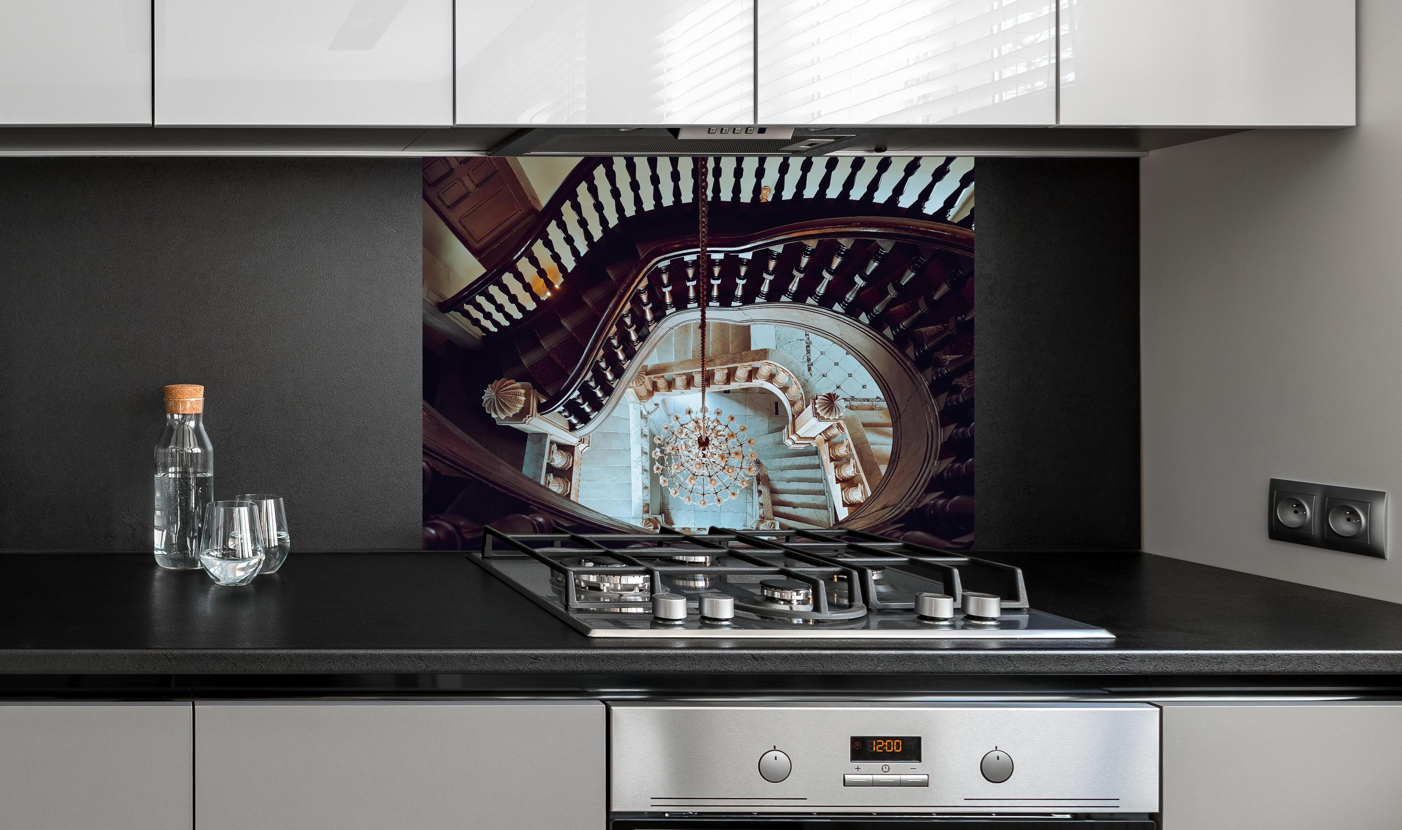 Spritzschutz - Alte Architektur - Baron Empain Palace hinter einem Cerankochfeld zwischen Holz-Kochutensilien
