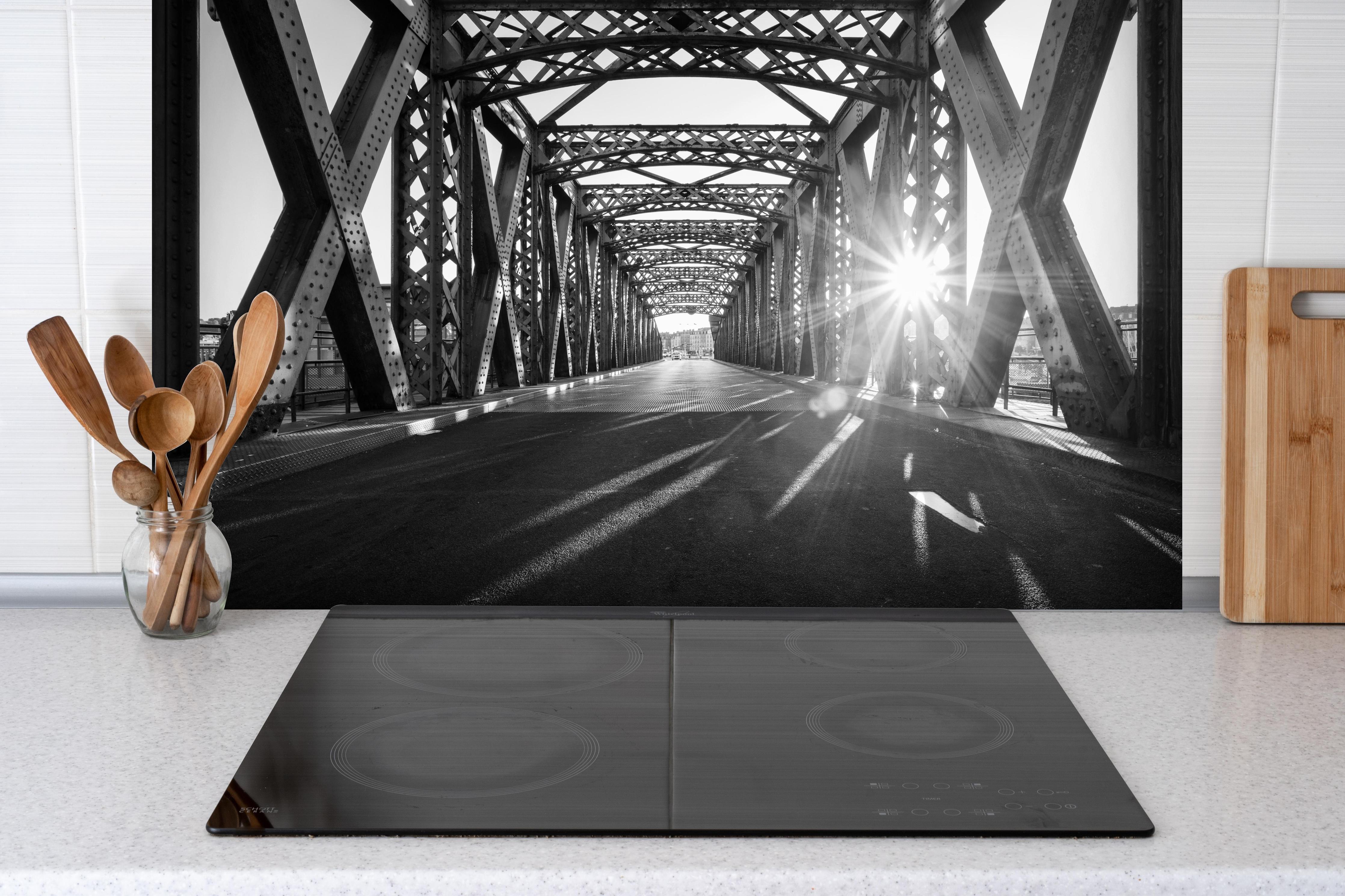 Spritzschutz - Alte Stadtbrücke hinter einem Cerankochfeld zwischen Holz-Kochutensilien
