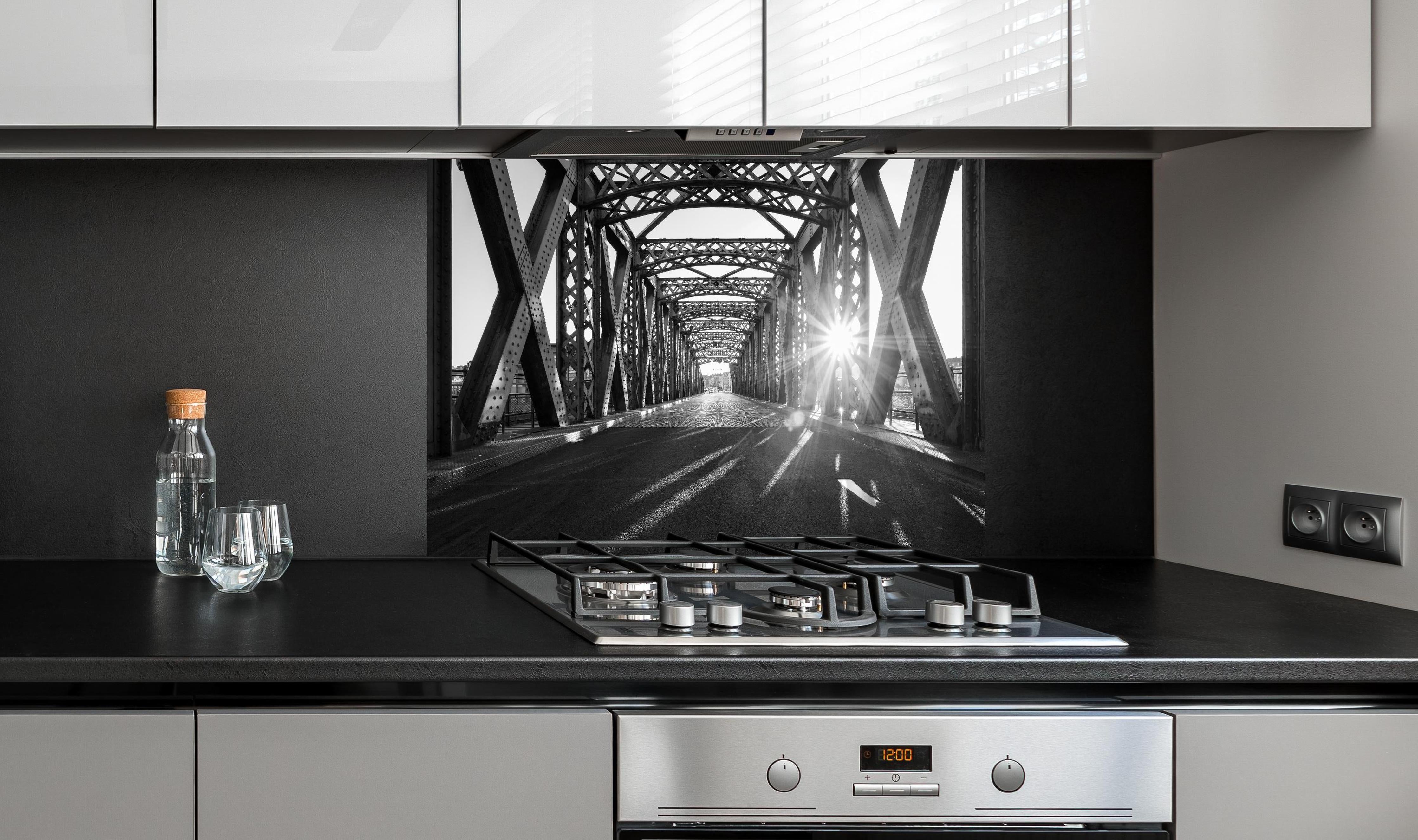 Spritzschutz - Alte Stadtbrücke hinter einem Cerankochfeld zwischen Holz-Kochutensilien
