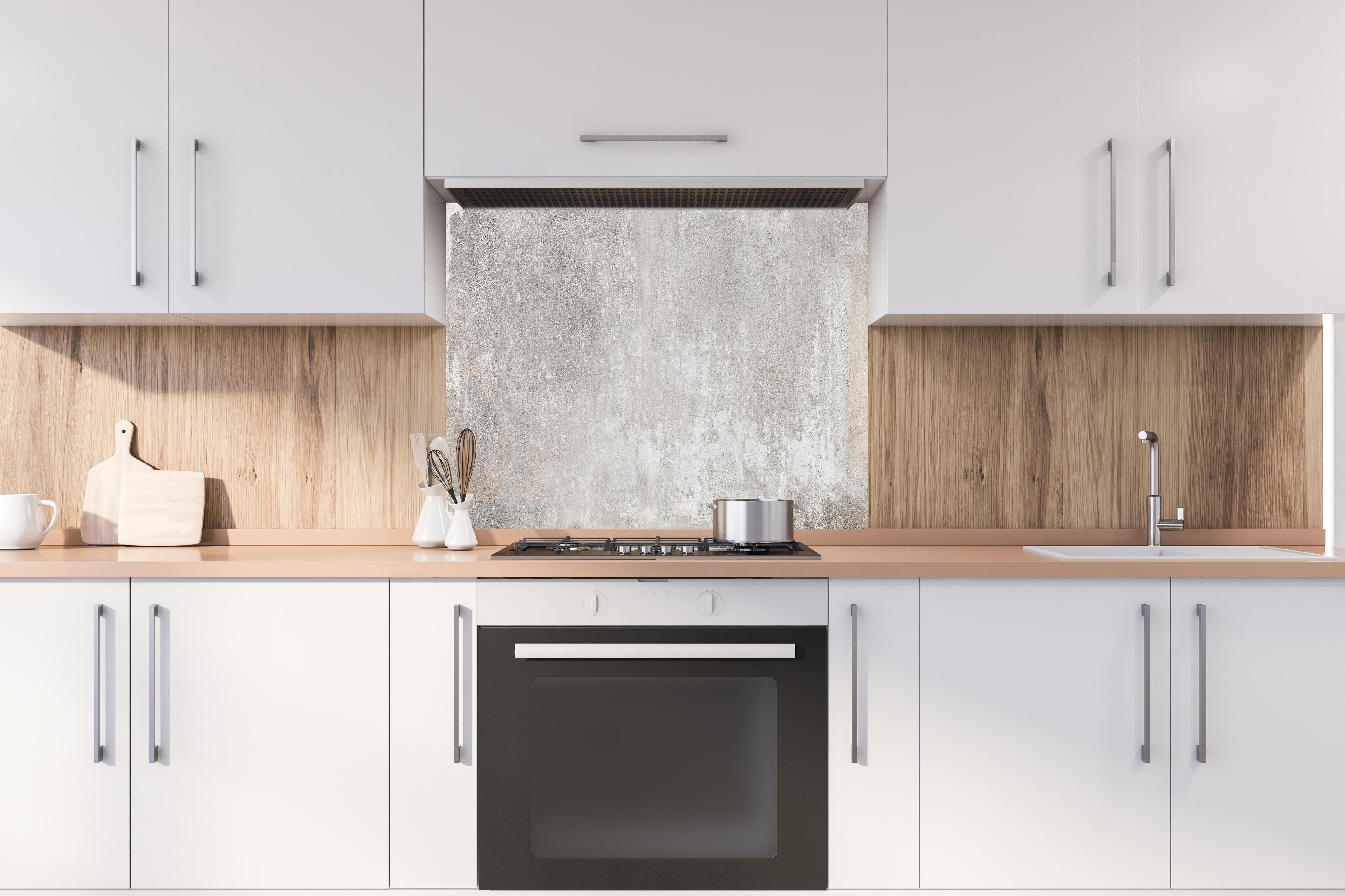 Spritzschutz - Alte Zementwandstruktur hinter einem Cerankochfeld zwischen Holz-Kochutensilien
