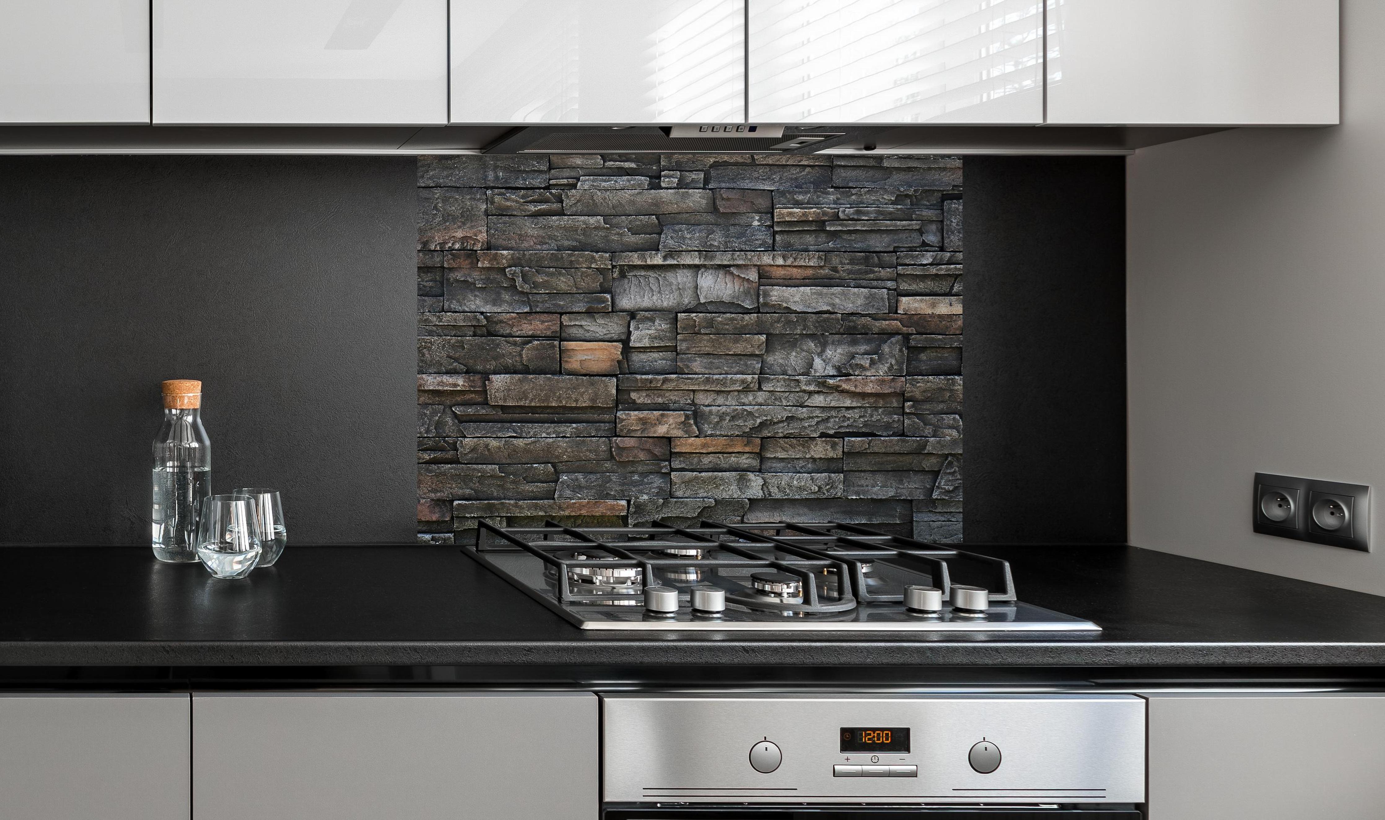 Spritzschutz - Alte dunkle Steinwand Textur hinter einem Cerankochfeld zwischen Holz-Kochutensilien
