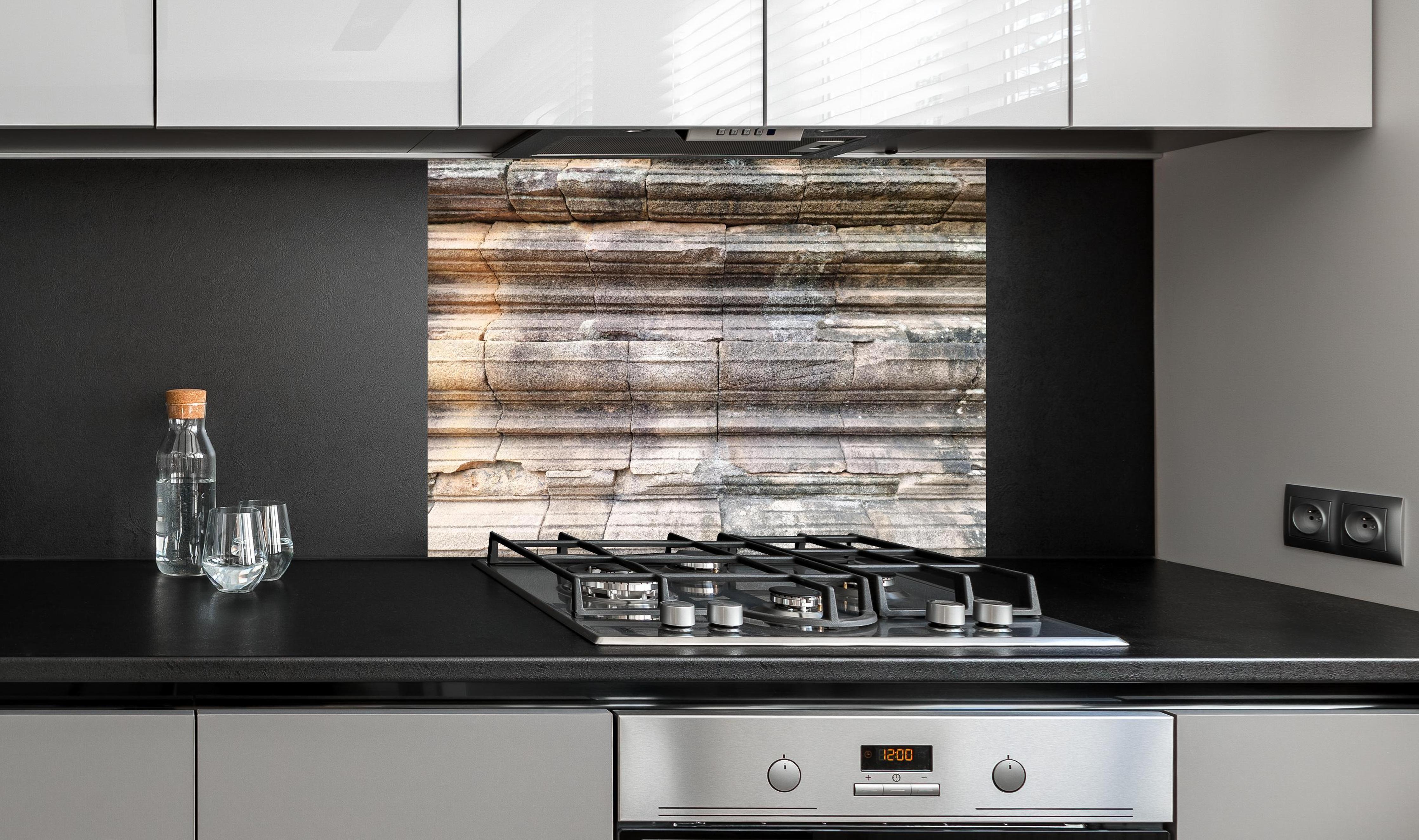 Spritzschutz - Alter Steinziegel - Grunge hinter einem Cerankochfeld zwischen Holz-Kochutensilien
