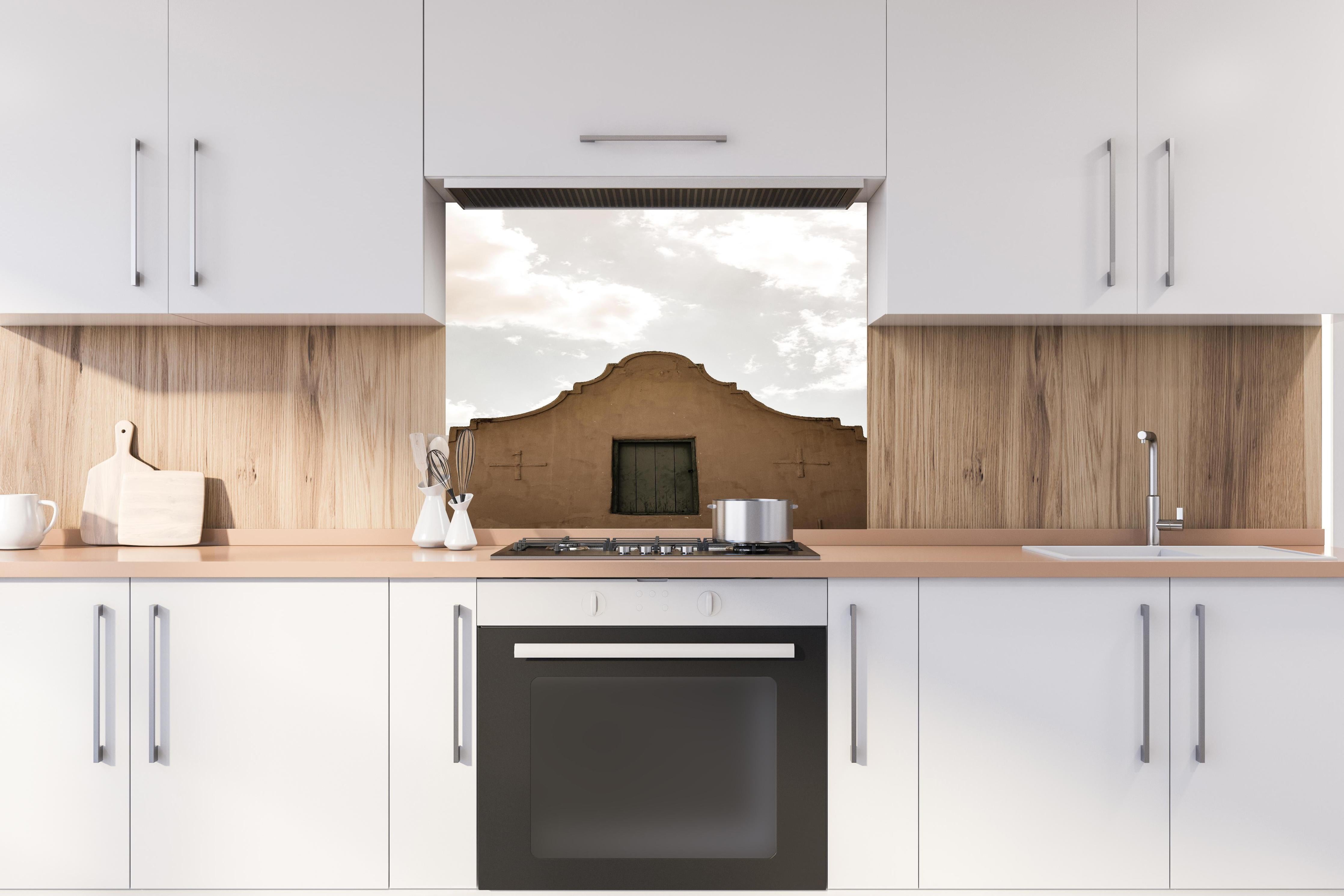 Spritzschutz - Altes Gebäude gegen bewölkten Himmel Kontrast hinter einem Cerankochfeld zwischen Holz-Kochutensilien
