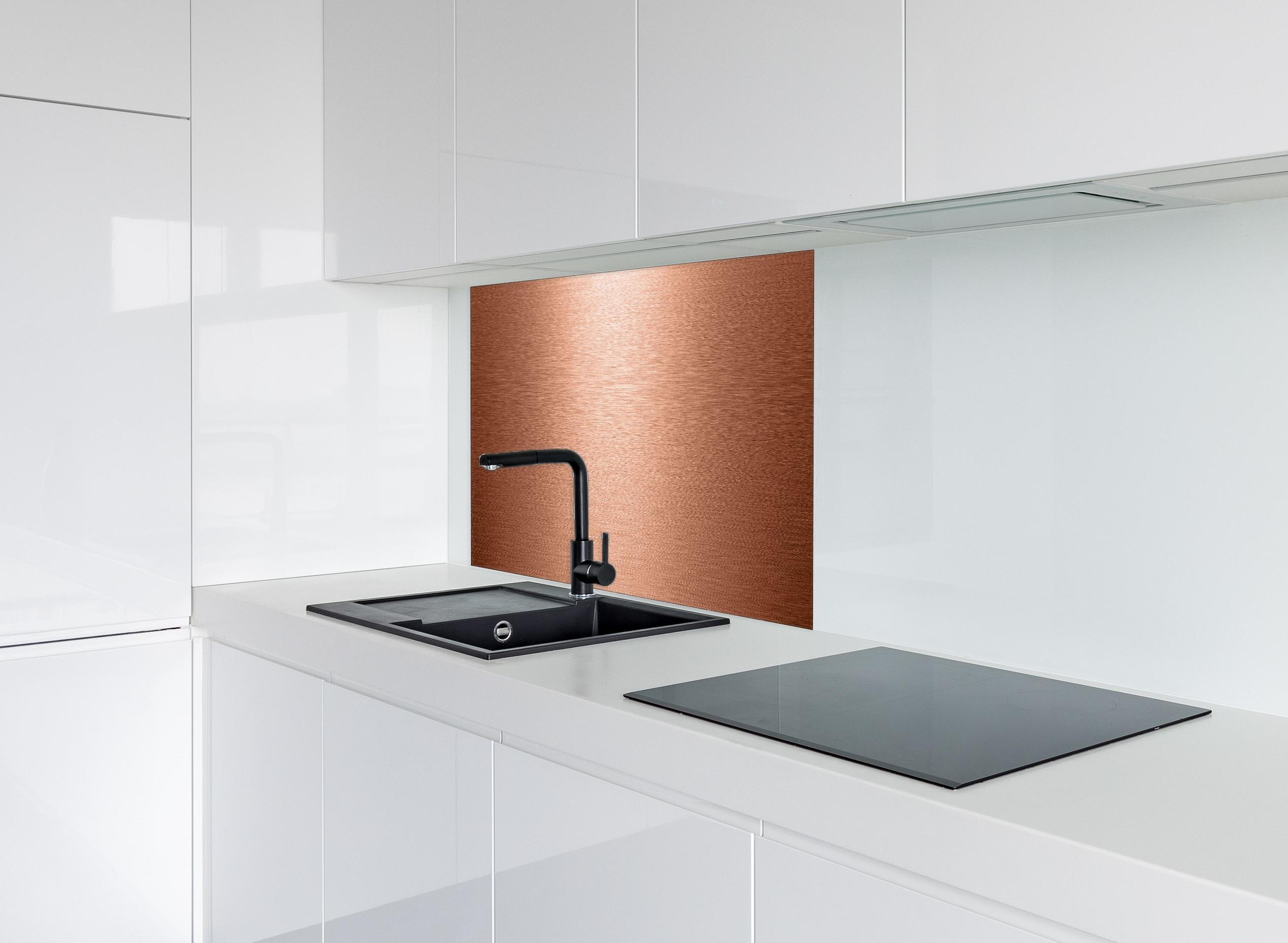 Spritzschutz - Alu gebürstet kupferfarbig hinter einem Cerankochfeld zwischen Holz-Kochutensilien
