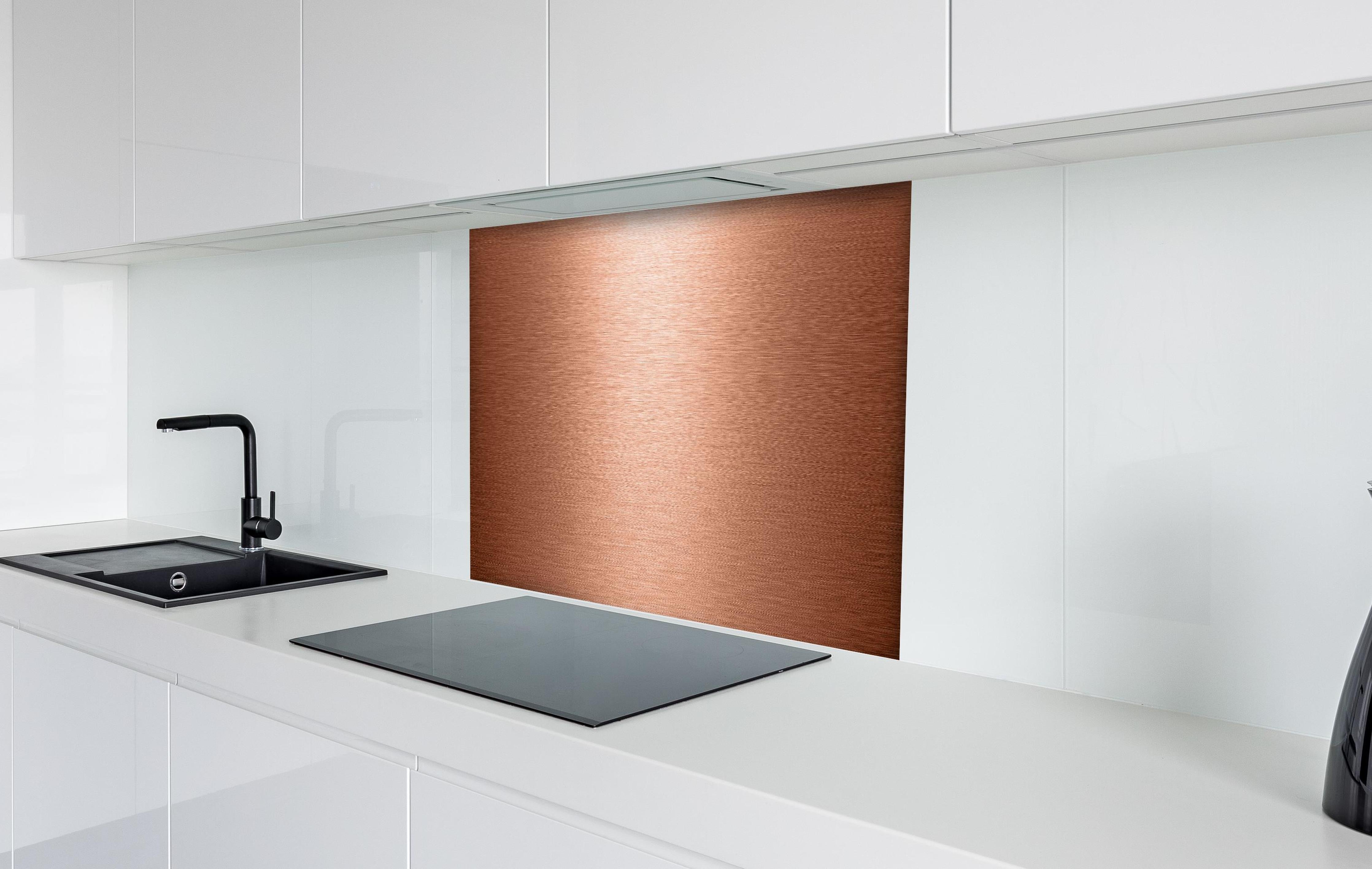 Spritzschutz - Alu gebürstet kupferfarbig hinter einem Cerankochfeld zwischen Holz-Kochutensilien
