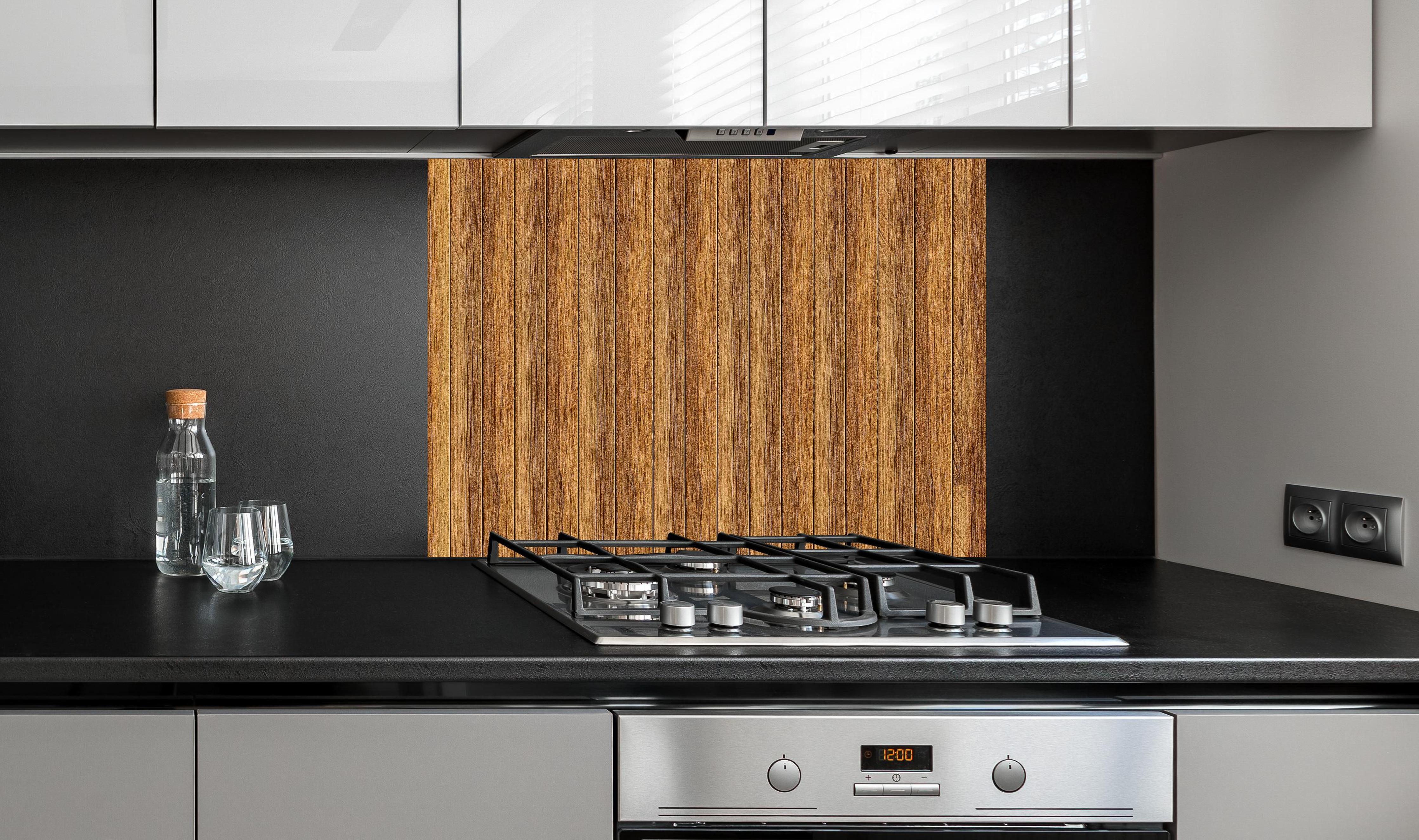 Spritzschutz - Aneinandergereihte braune Holzplanken hinter einem Cerankochfeld zwischen Holz-Kochutensilien
