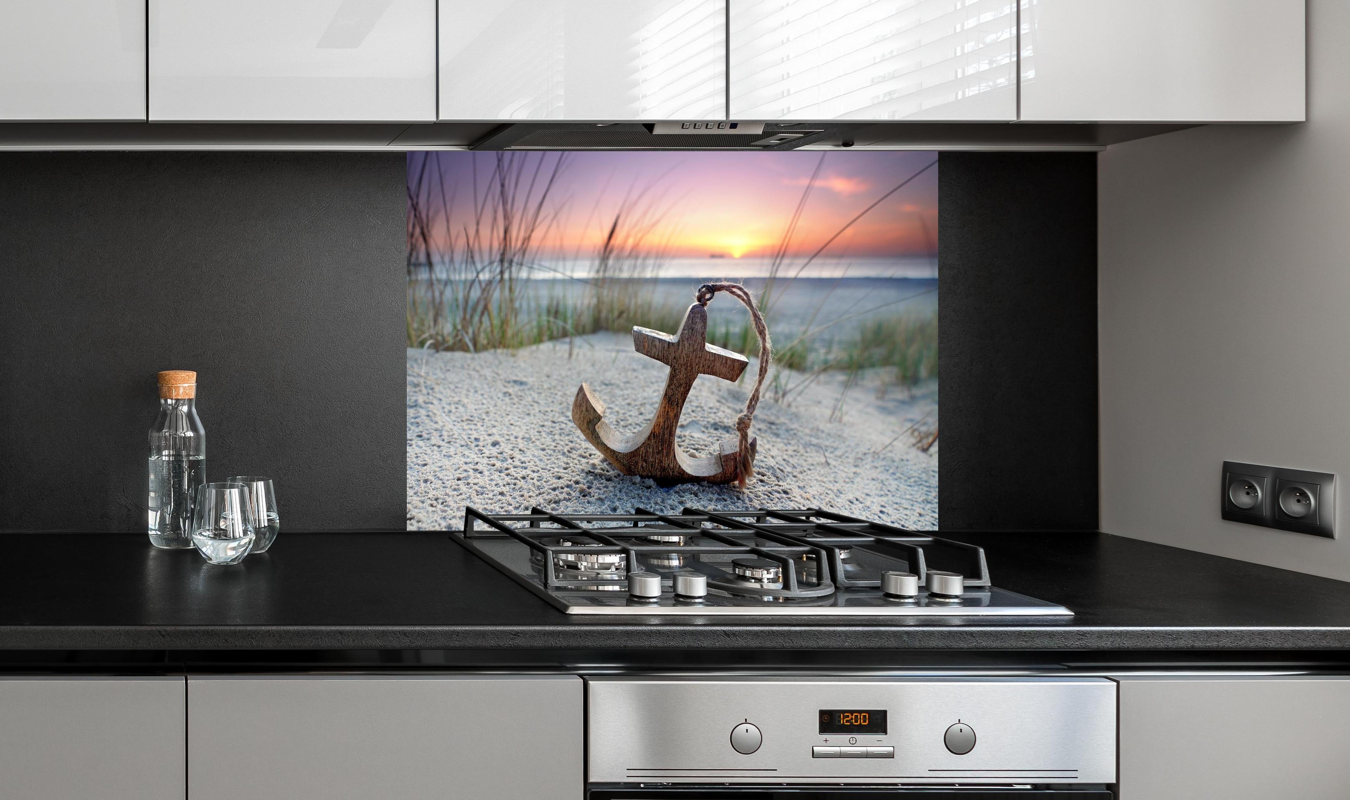 Spritzschutz - Anker am Strand hinter einem Cerankochfeld zwischen Holz-Kochutensilien
