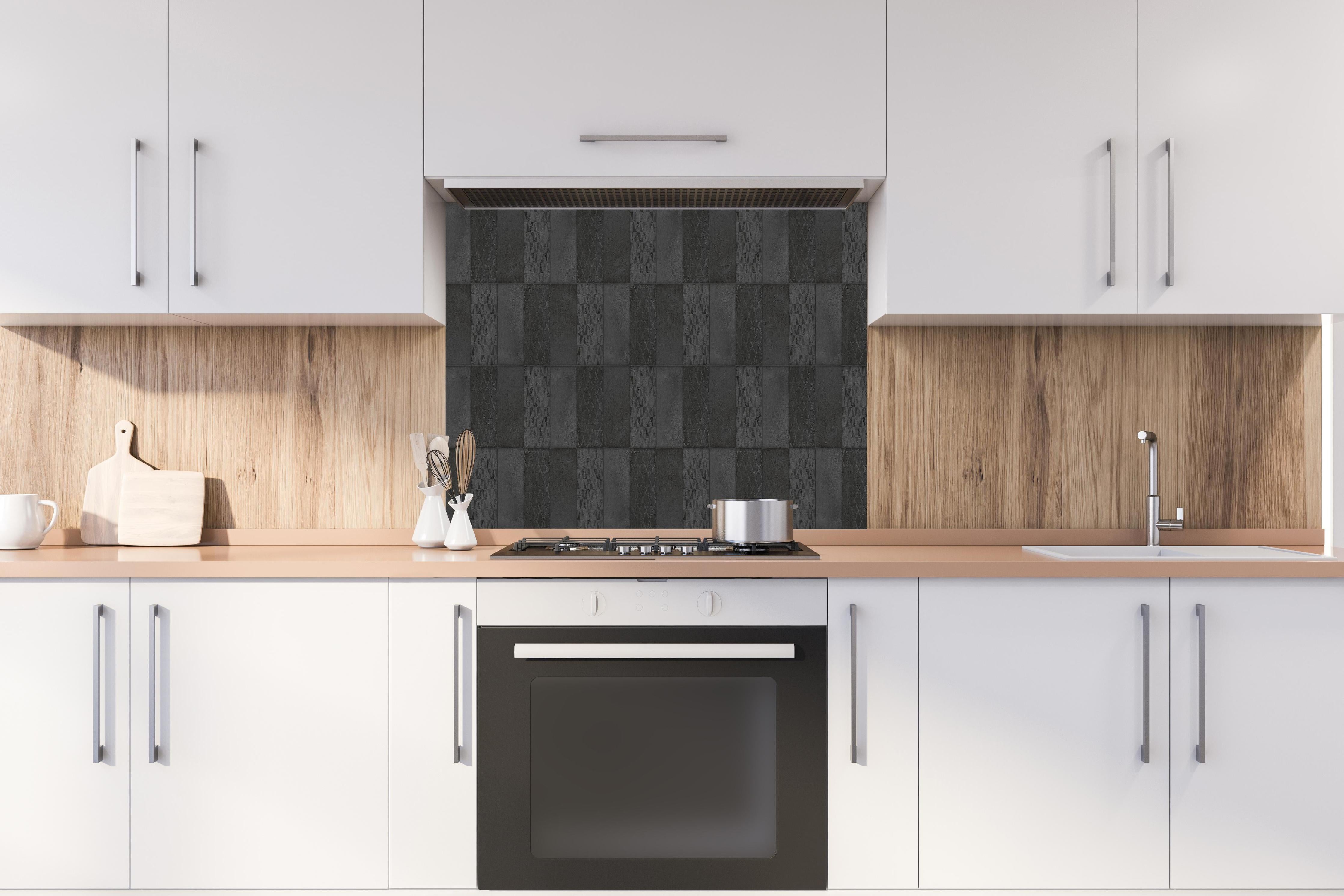 Spritzschutz - Anthrazitfarbene vintage Fliesen hinter einem Cerankochfeld zwischen Holz-Kochutensilien
