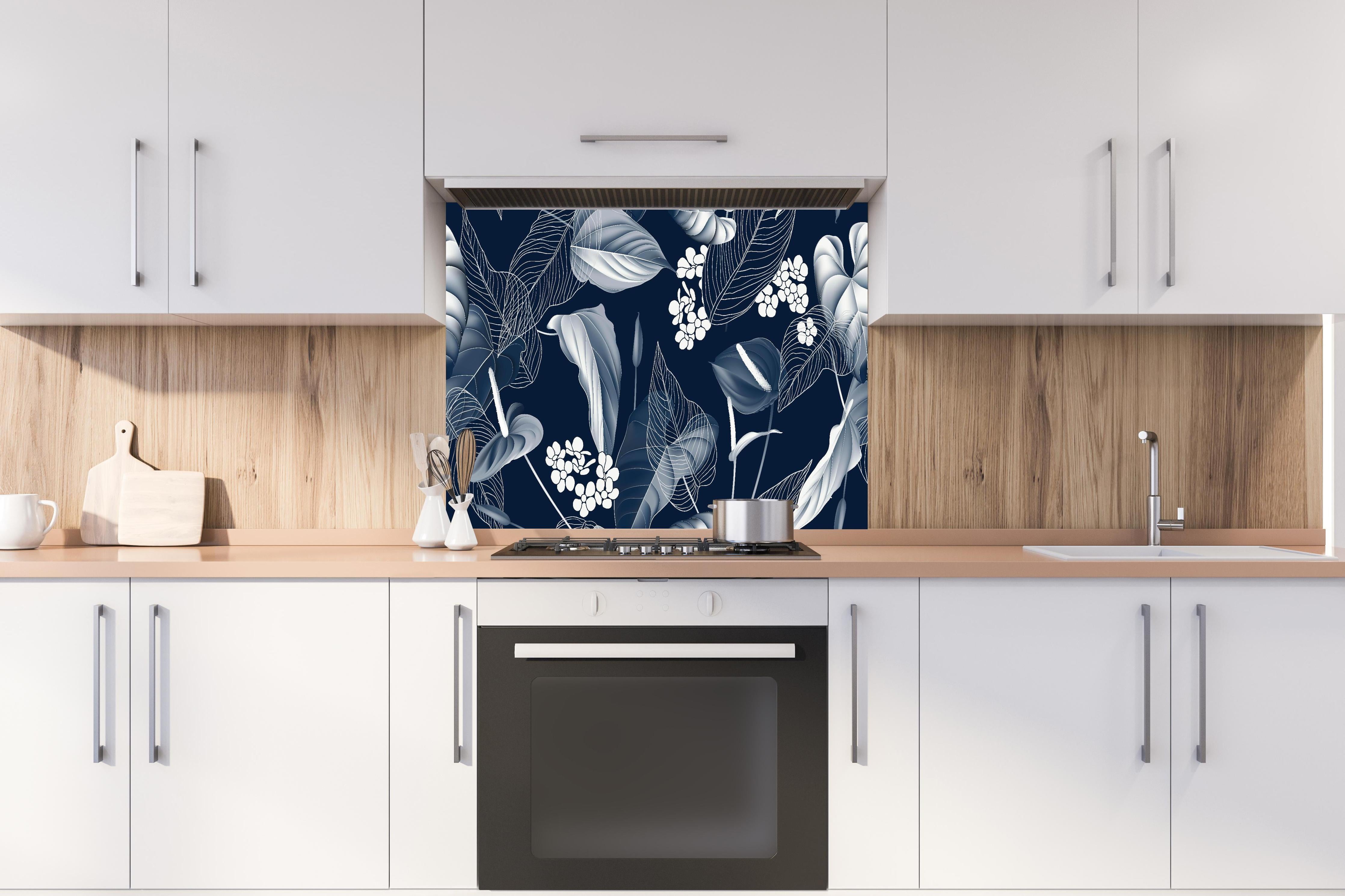 Spritzschutz - Anthurium Blumenmuster Blautöne auf Dunkelblau hinter einem Cerankochfeld zwischen Holz-Kochutensilien
