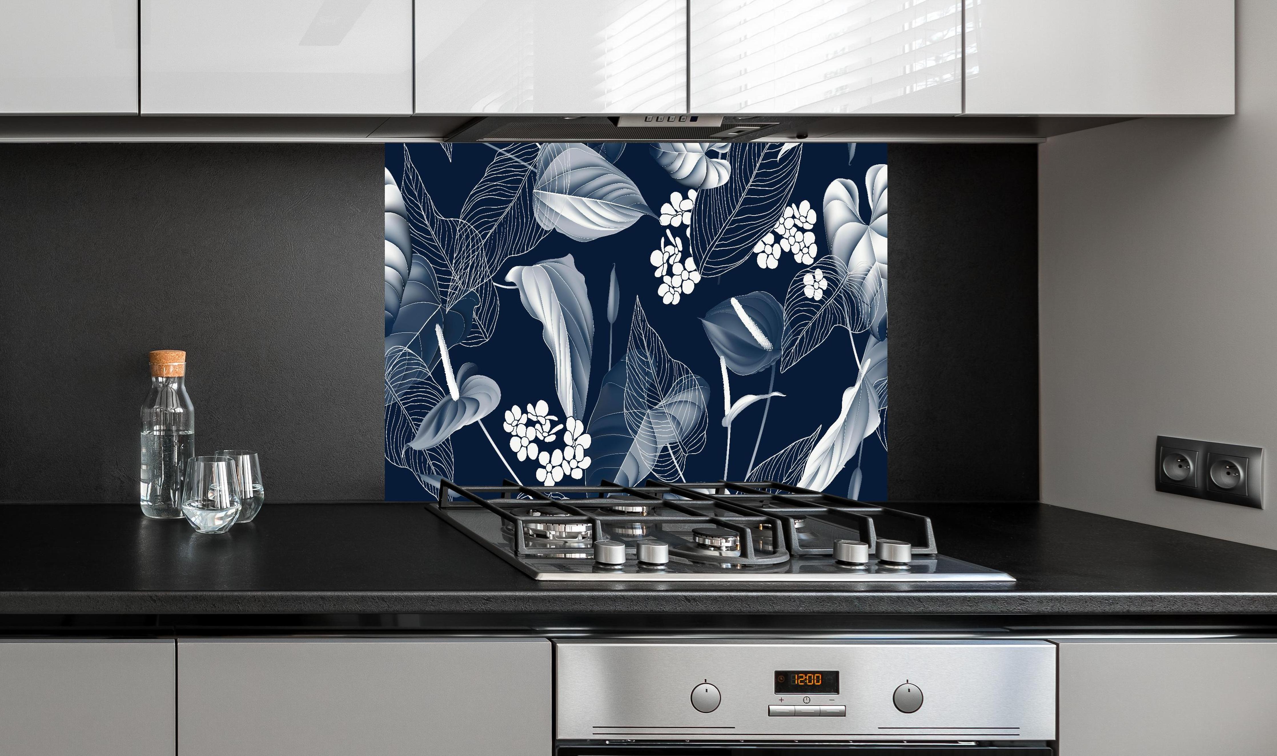 Spritzschutz - Anthurium Blumenmuster Blautöne auf Dunkelblau hinter einem Cerankochfeld zwischen Holz-Kochutensilien
