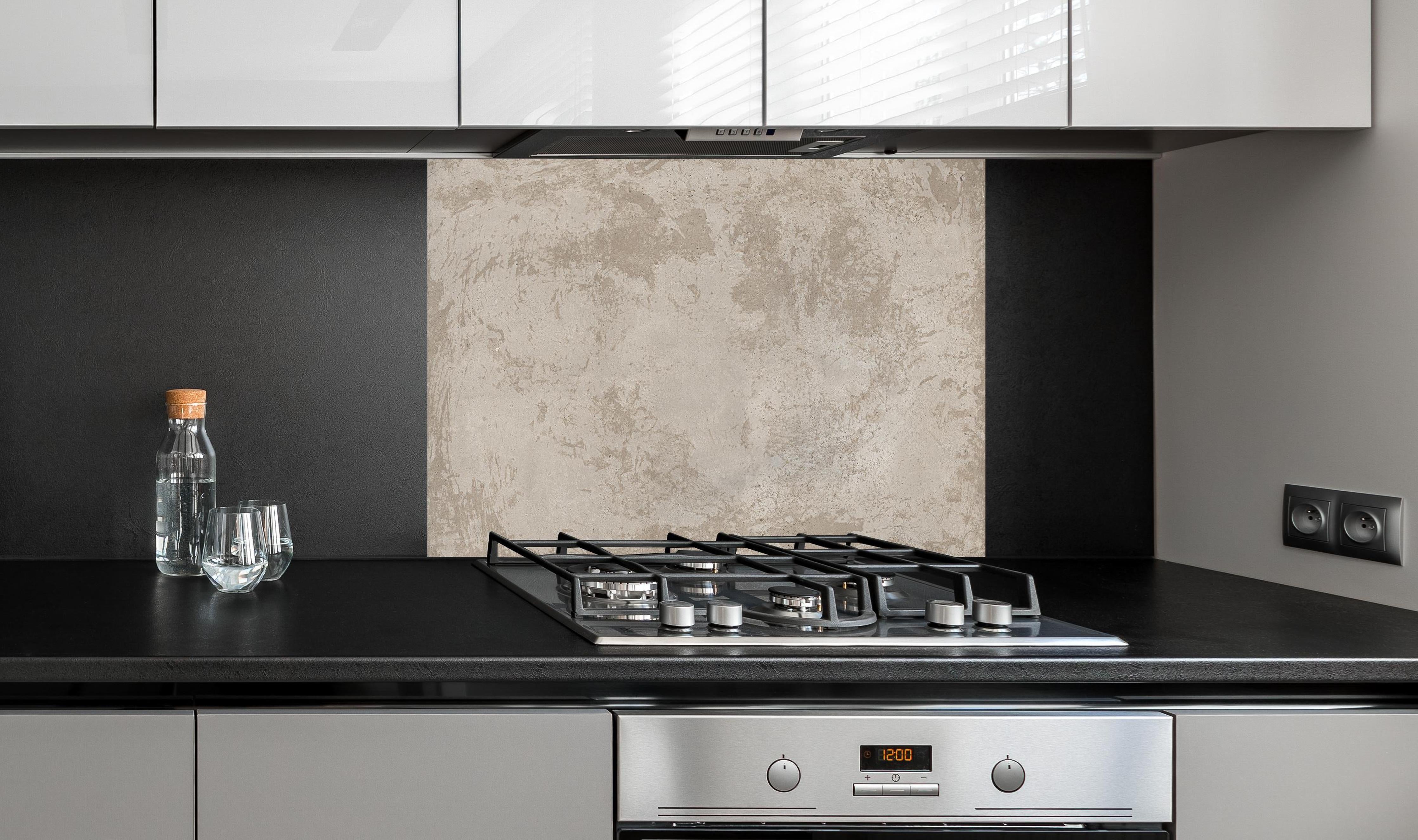 Spritzschutz - Antik beige Betonwand hinter einem Cerankochfeld zwischen Holz-Kochutensilien
