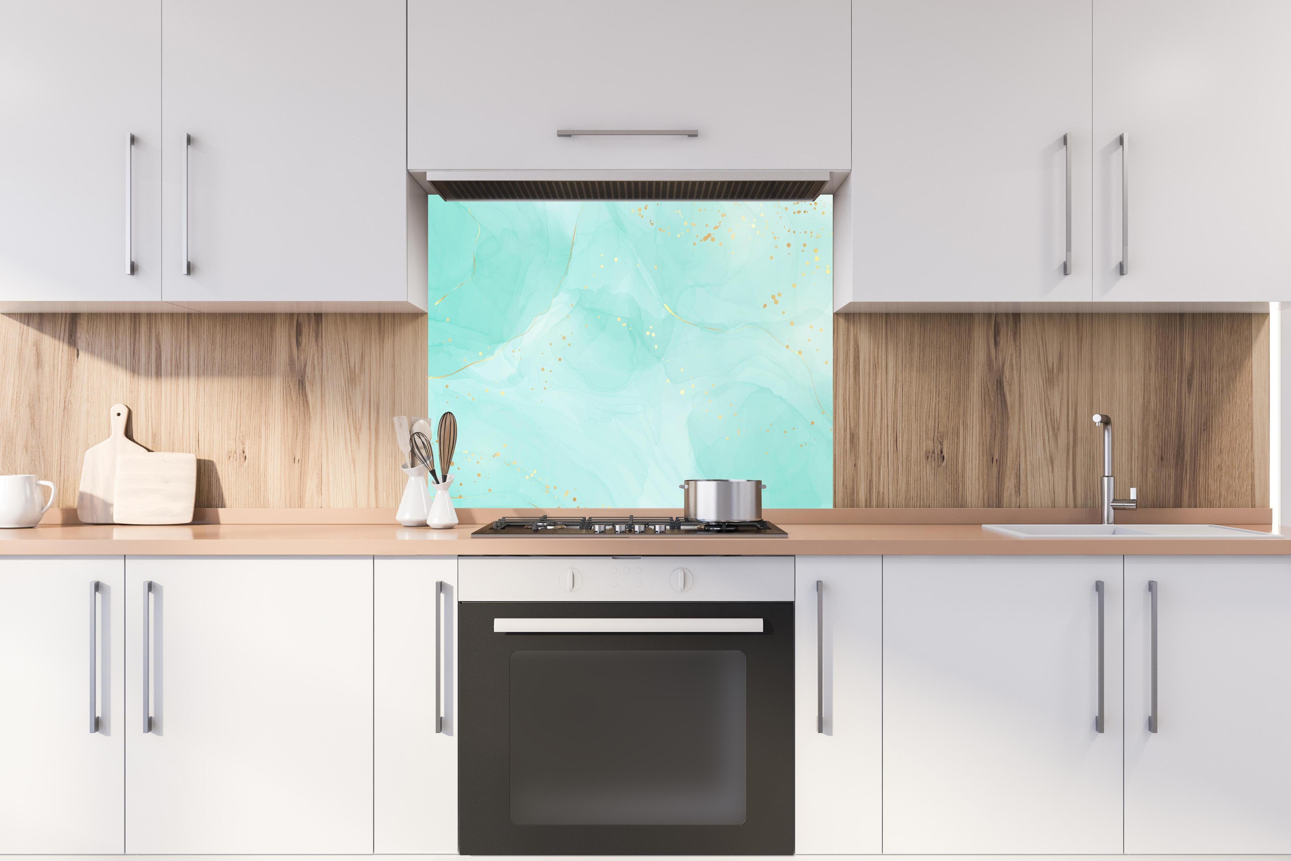 Spritzschutz - Aquarell Kunst Design in Türkis mit Goldsprenkeln hinter einem Cerankochfeld zwischen Holz-Kochutensilien
