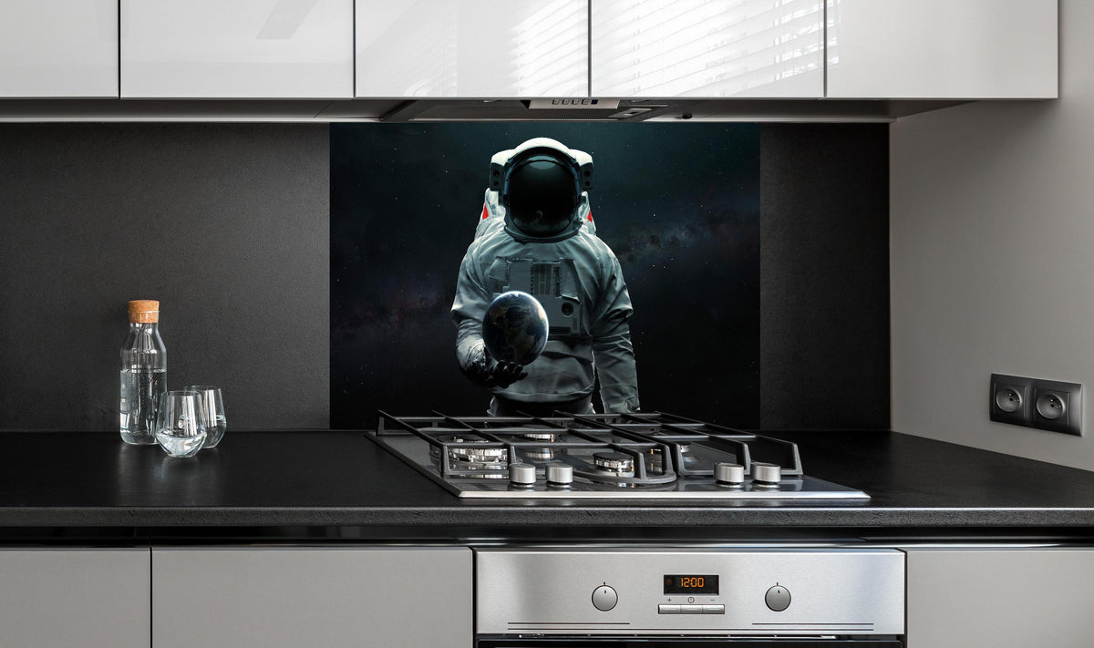 Spritzschutz - Astronaut hält Erde 3D-Kunst Sci-Fi hinter einem Cerankochfeld zwischen Holz-Kochutensilien
