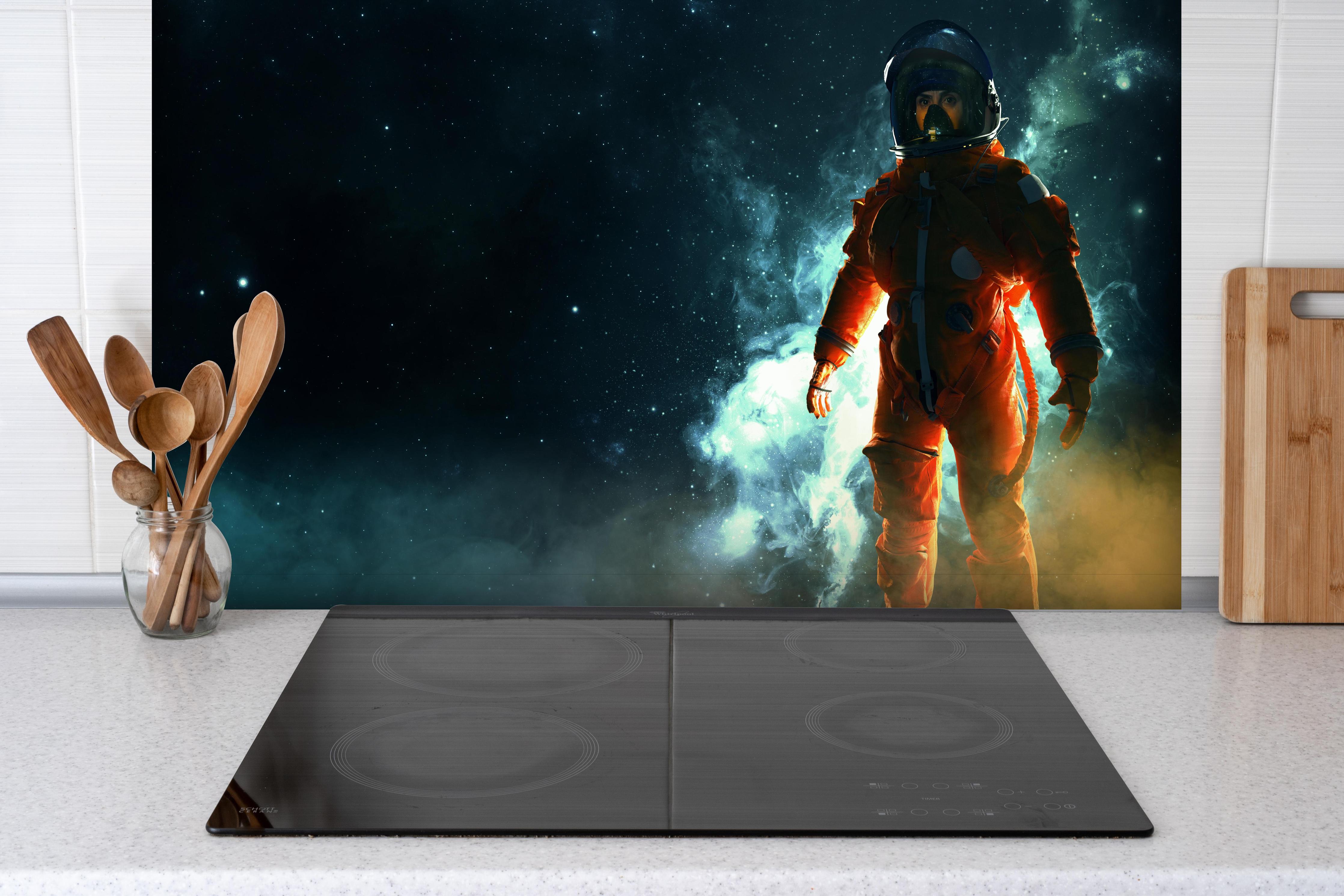 Spritzschutz - Astronaut im Weltraum hinter einem Cerankochfeld zwischen Holz-Kochutensilien
