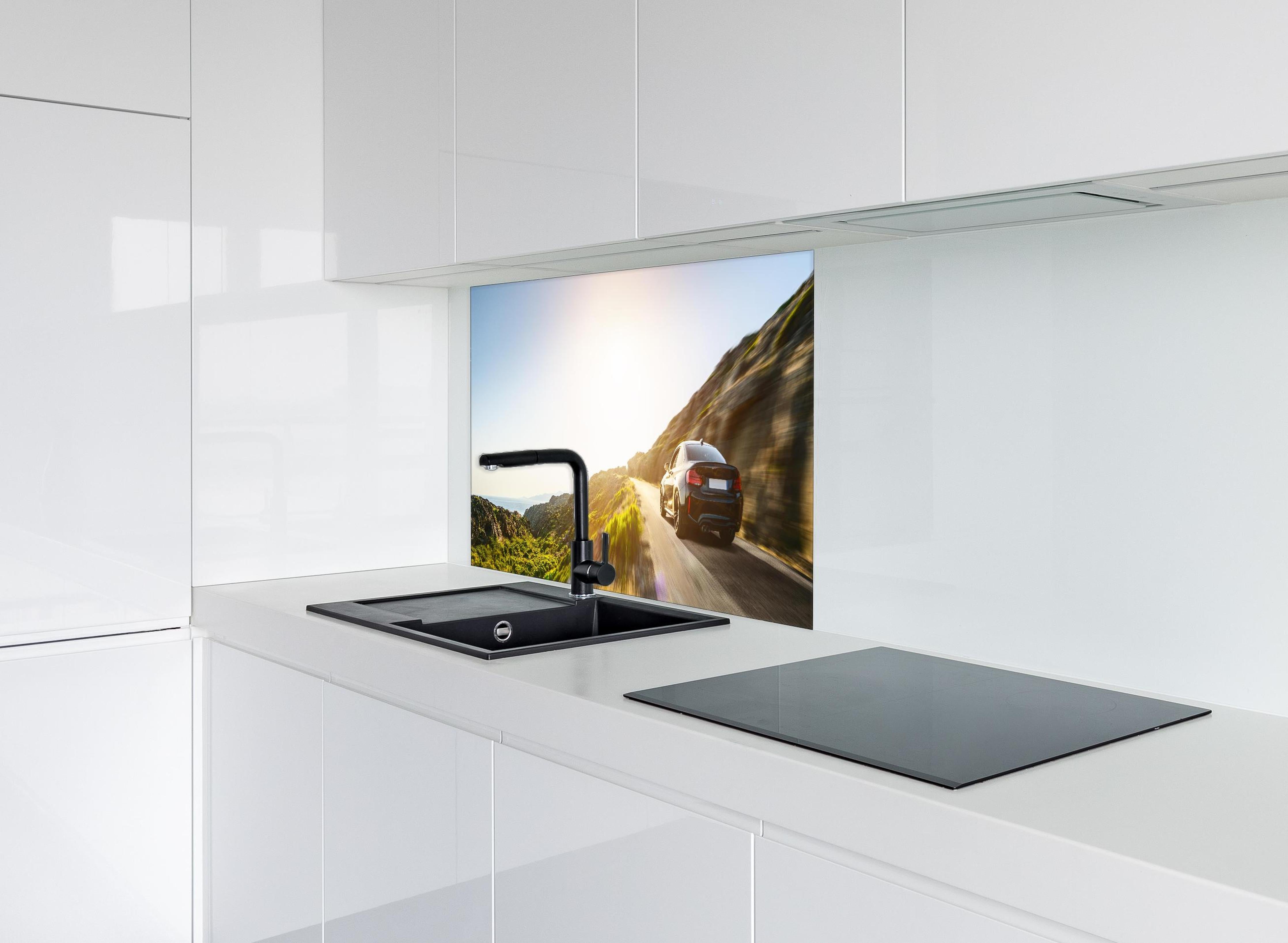 Spritzschutz - Auto fährt über eine Straße auf Bergen hinter einem Cerankochfeld zwischen Holz-Kochutensilien
