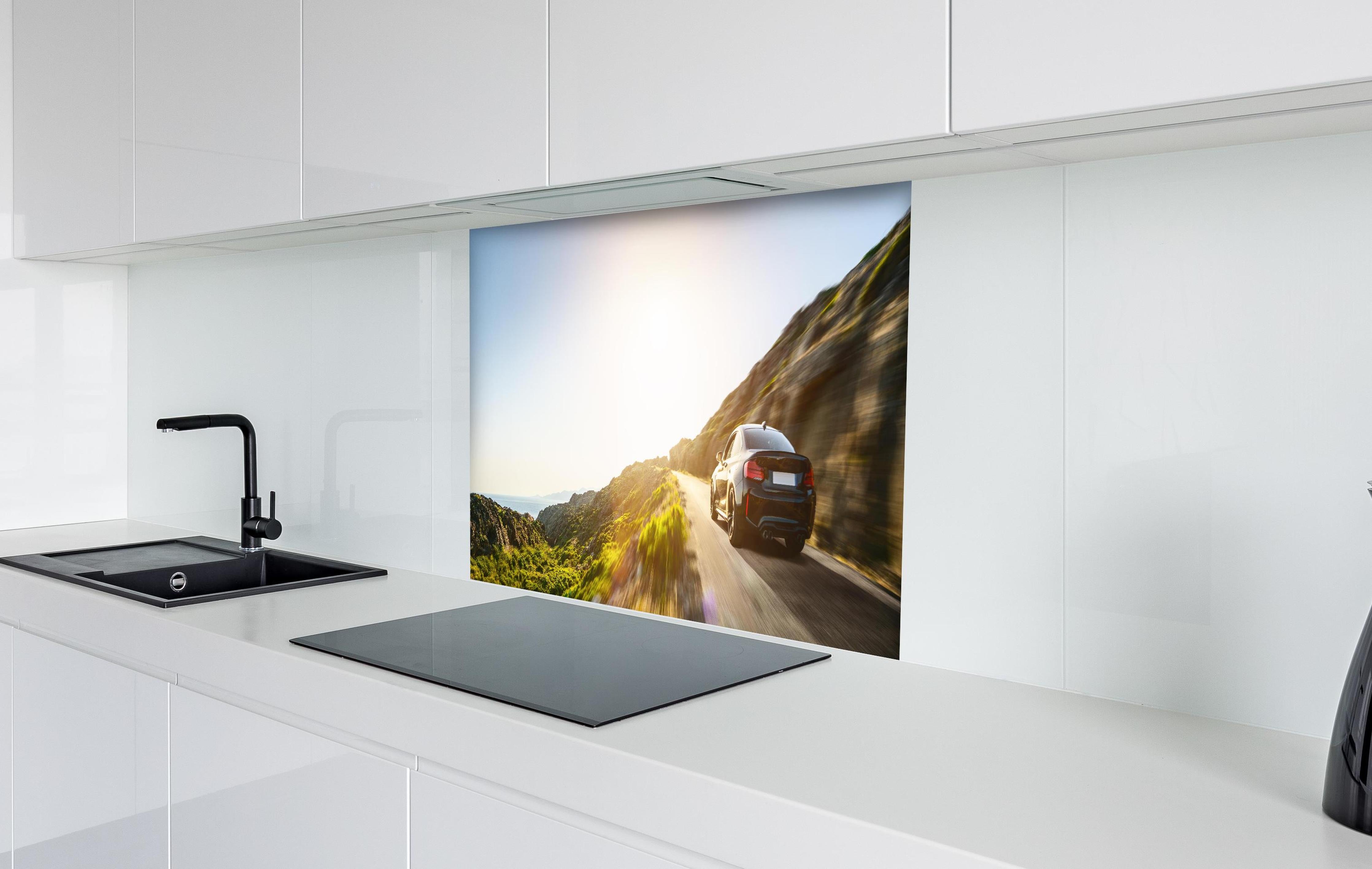 Spritzschutz - Auto fährt über eine Straße auf Bergen hinter einem Cerankochfeld zwischen Holz-Kochutensilien
