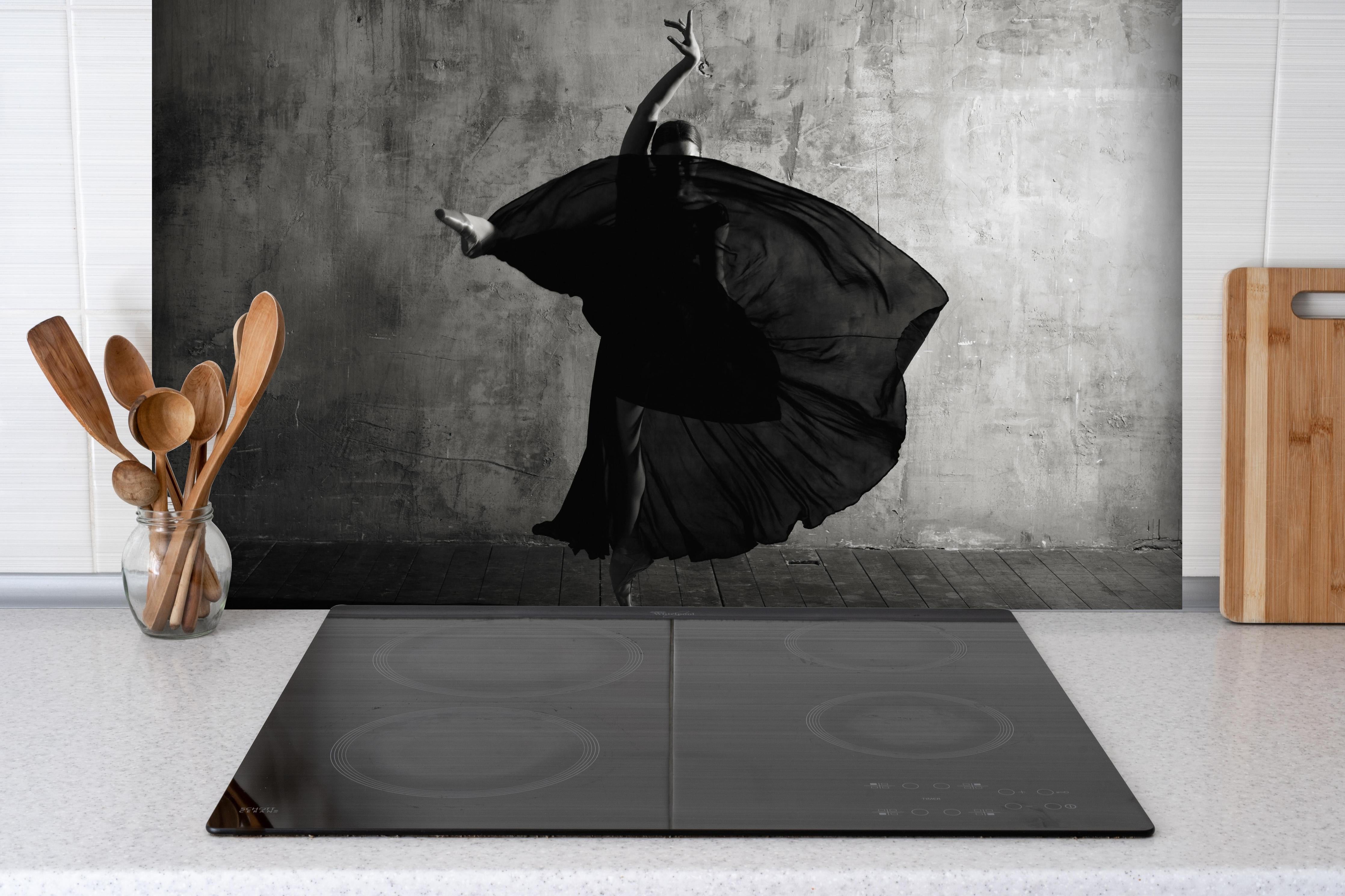 Spritzschutz - Ballerina im Ballsaal hinter einem Cerankochfeld zwischen Holz-Kochutensilien
