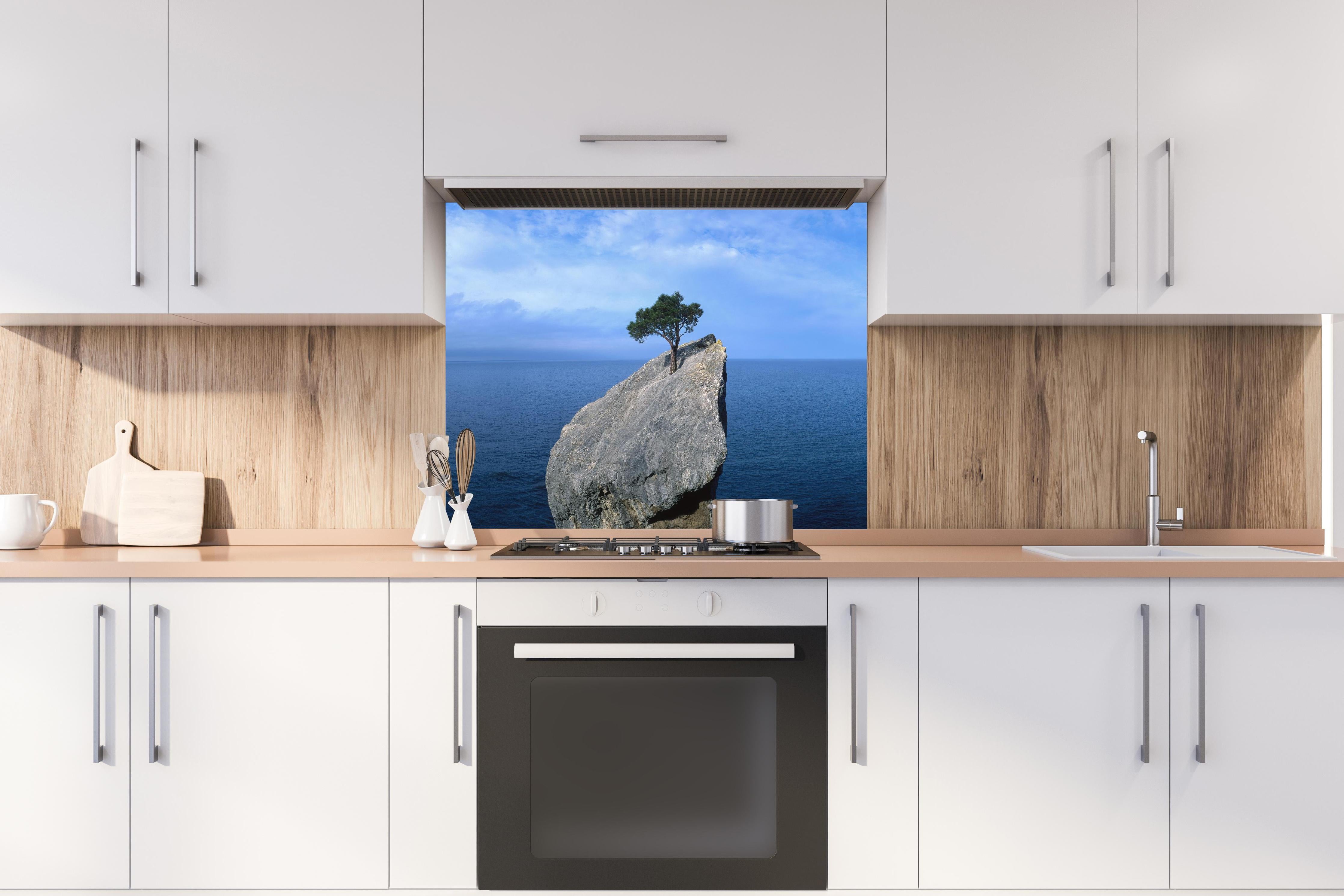 Spritzschutz - Baum auf Fels mitten im Ozean hinter einem Cerankochfeld zwischen Holz-Kochutensilien
