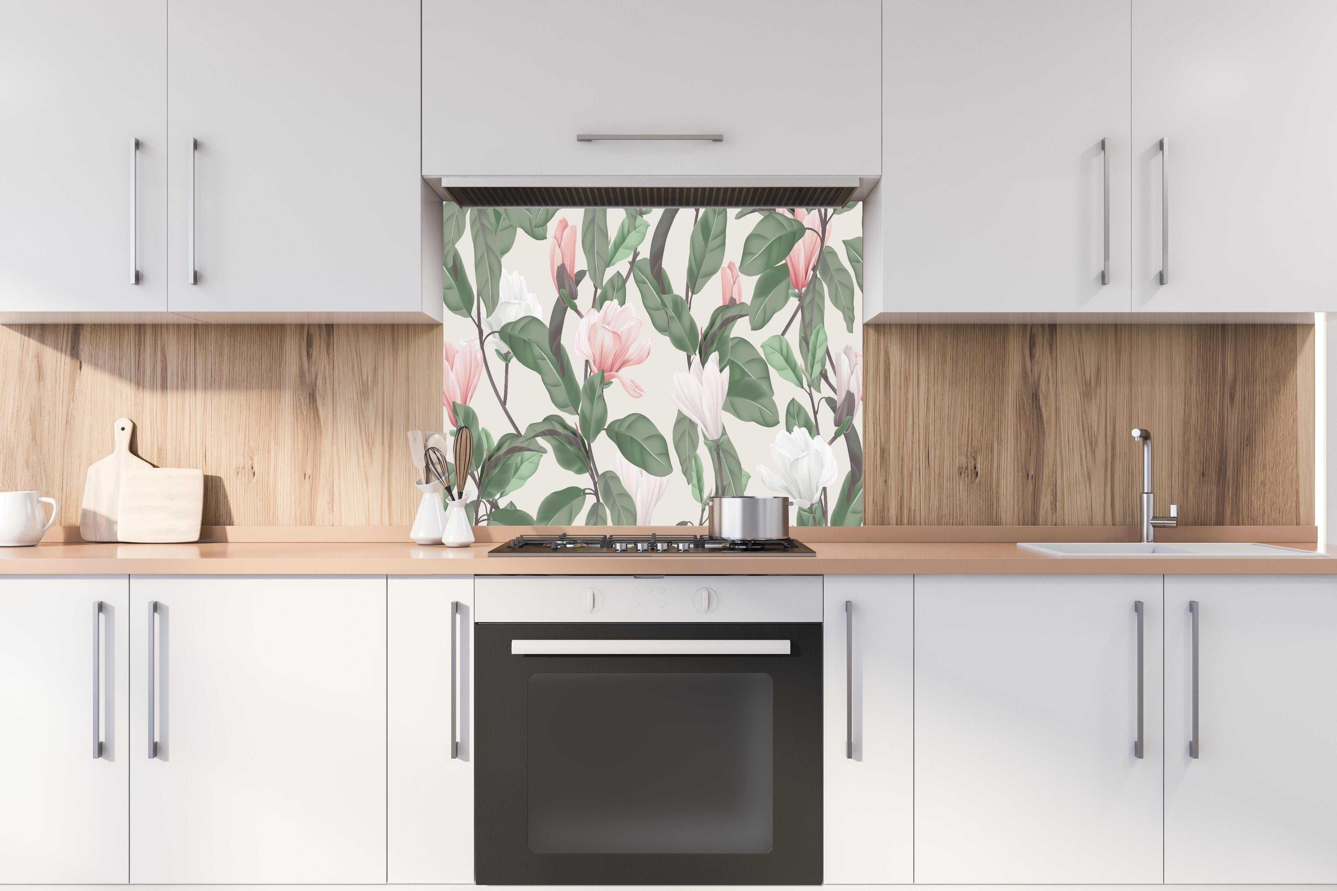 Spritzschutz - Beige Anise Magnolien Blumenmuster hinter einem Cerankochfeld zwischen Holz-Kochutensilien
