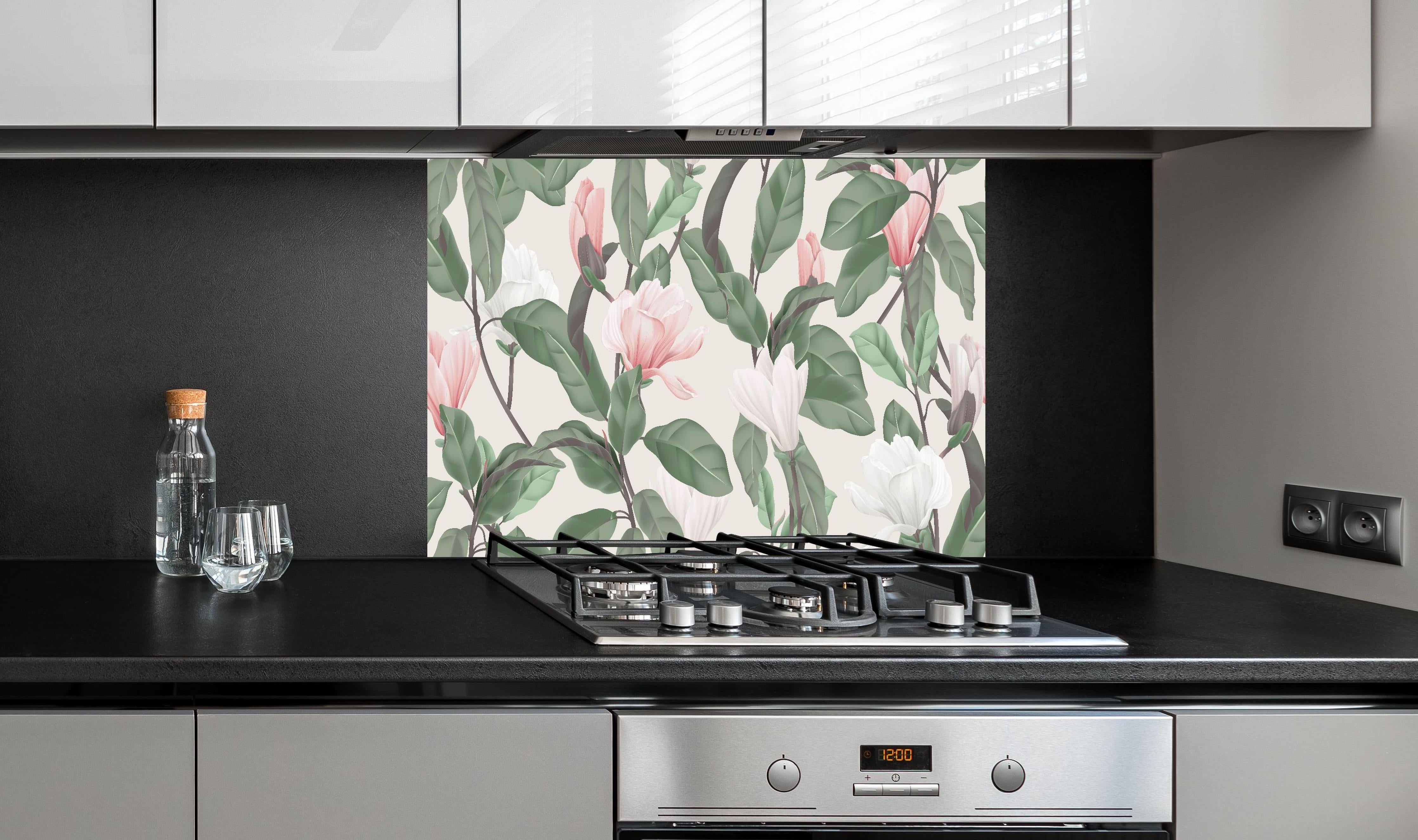 Spritzschutz - Beige Anise Magnolien Blumenmuster hinter einem Cerankochfeld zwischen Holz-Kochutensilien
