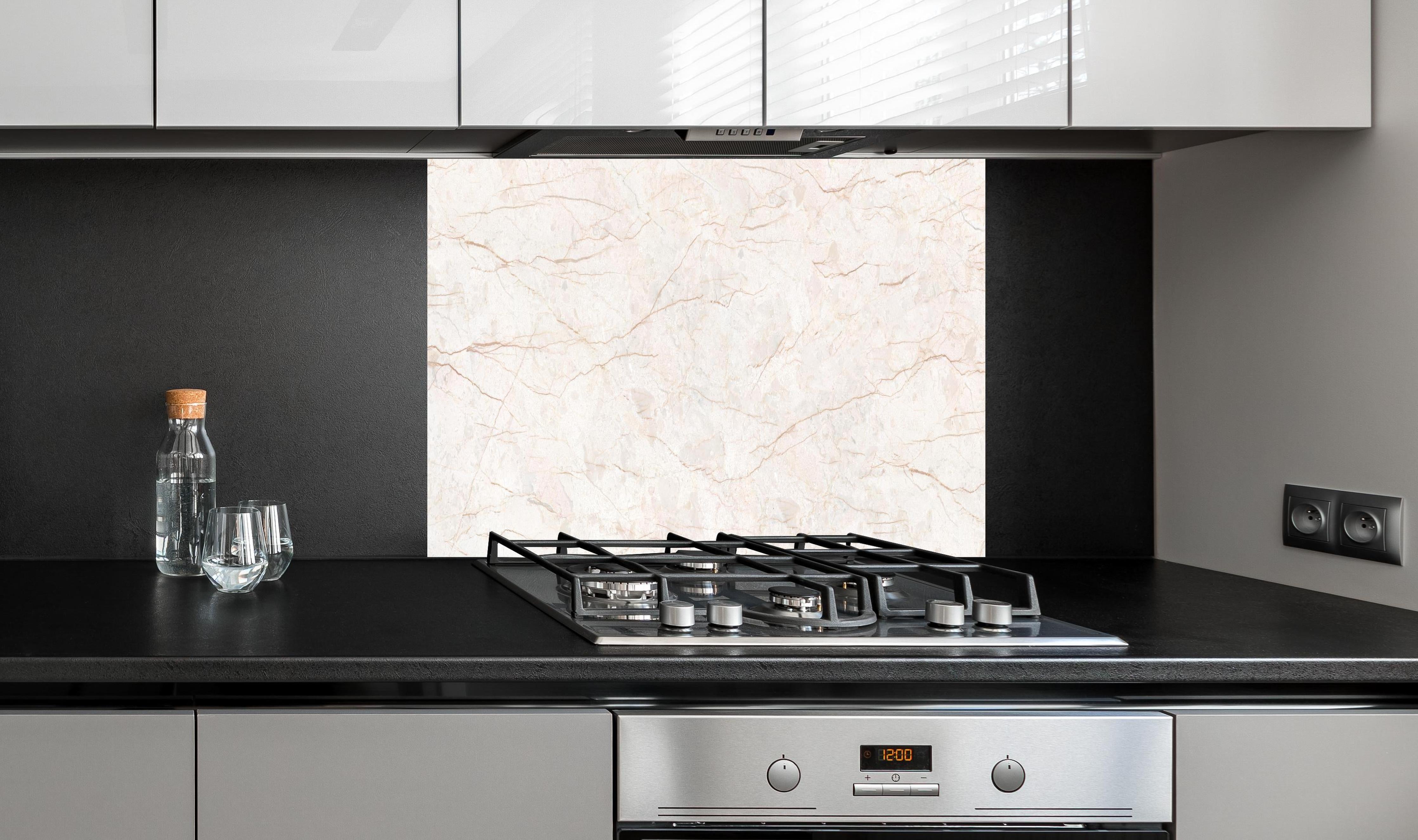 Spritzschutz - Beige Marmor Hintergrund hinter einem Cerankochfeld zwischen Holz-Kochutensilien
