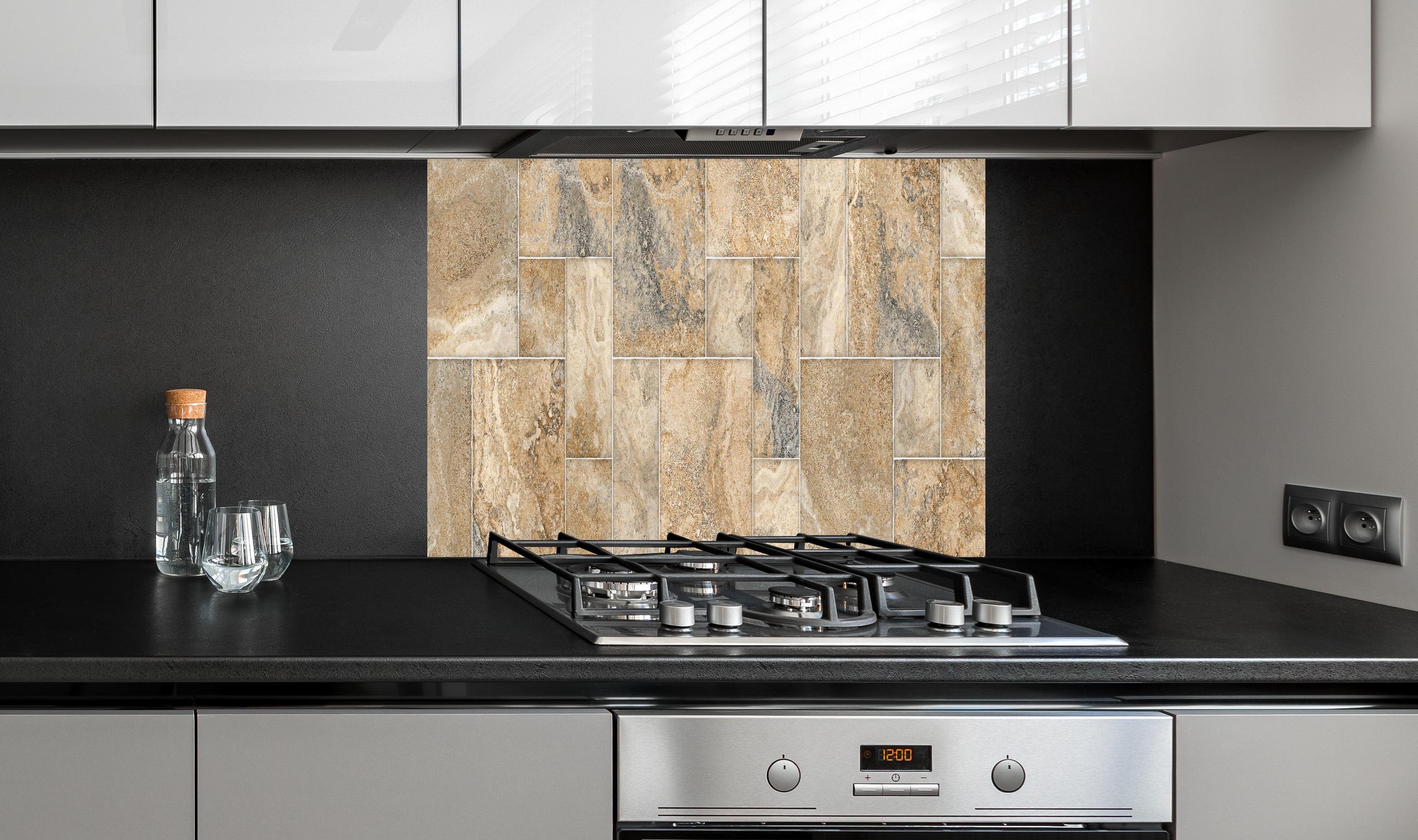 Spritzschutz - Beige Wandtextur aus Natursteinblöcken hinter einem Cerankochfeld zwischen Holz-Kochutensilien
