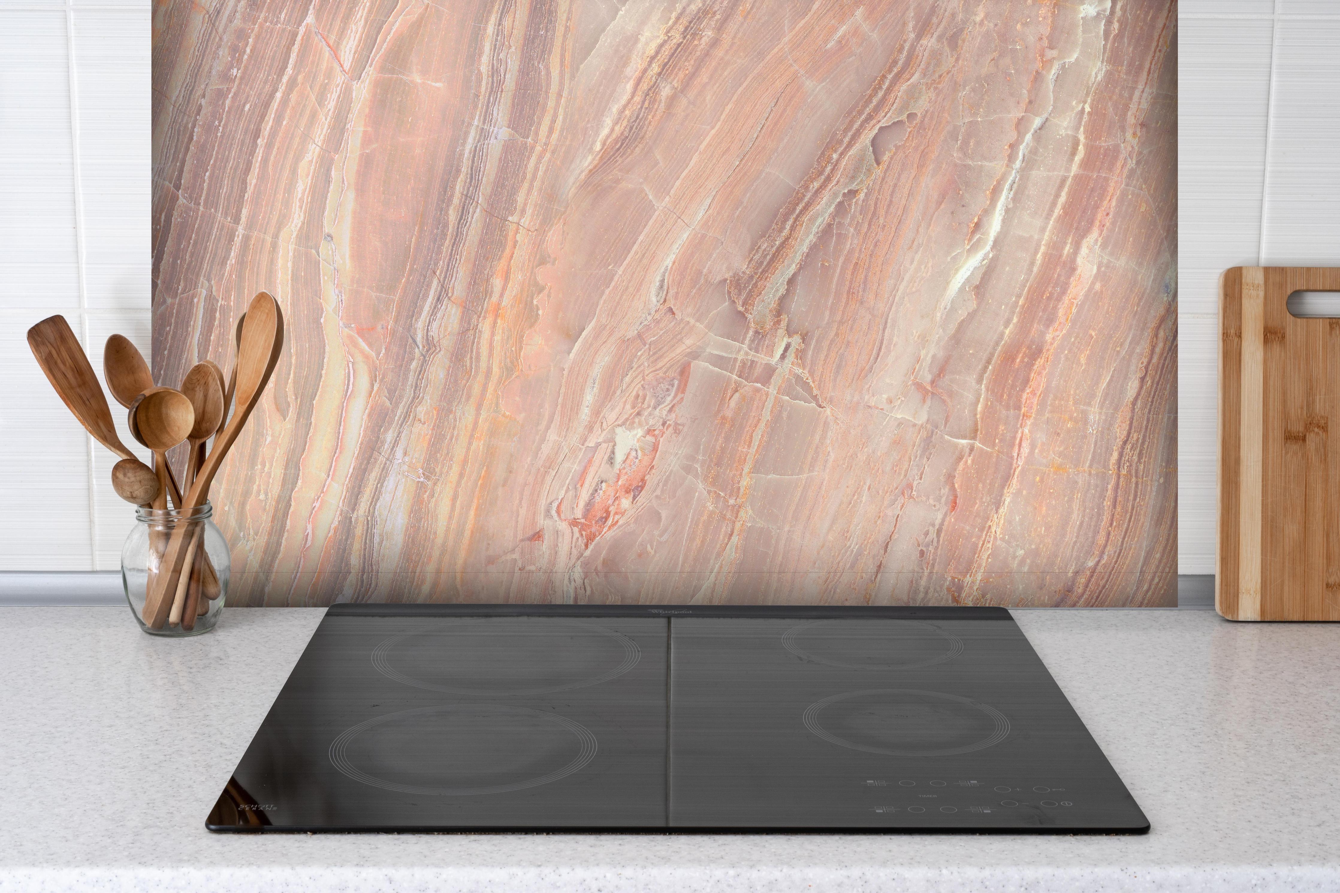 Spritzschutz - Beiges Marmor Design - Nahaufnahme hinter einem Cerankochfeld zwischen Holz-Kochutensilien
