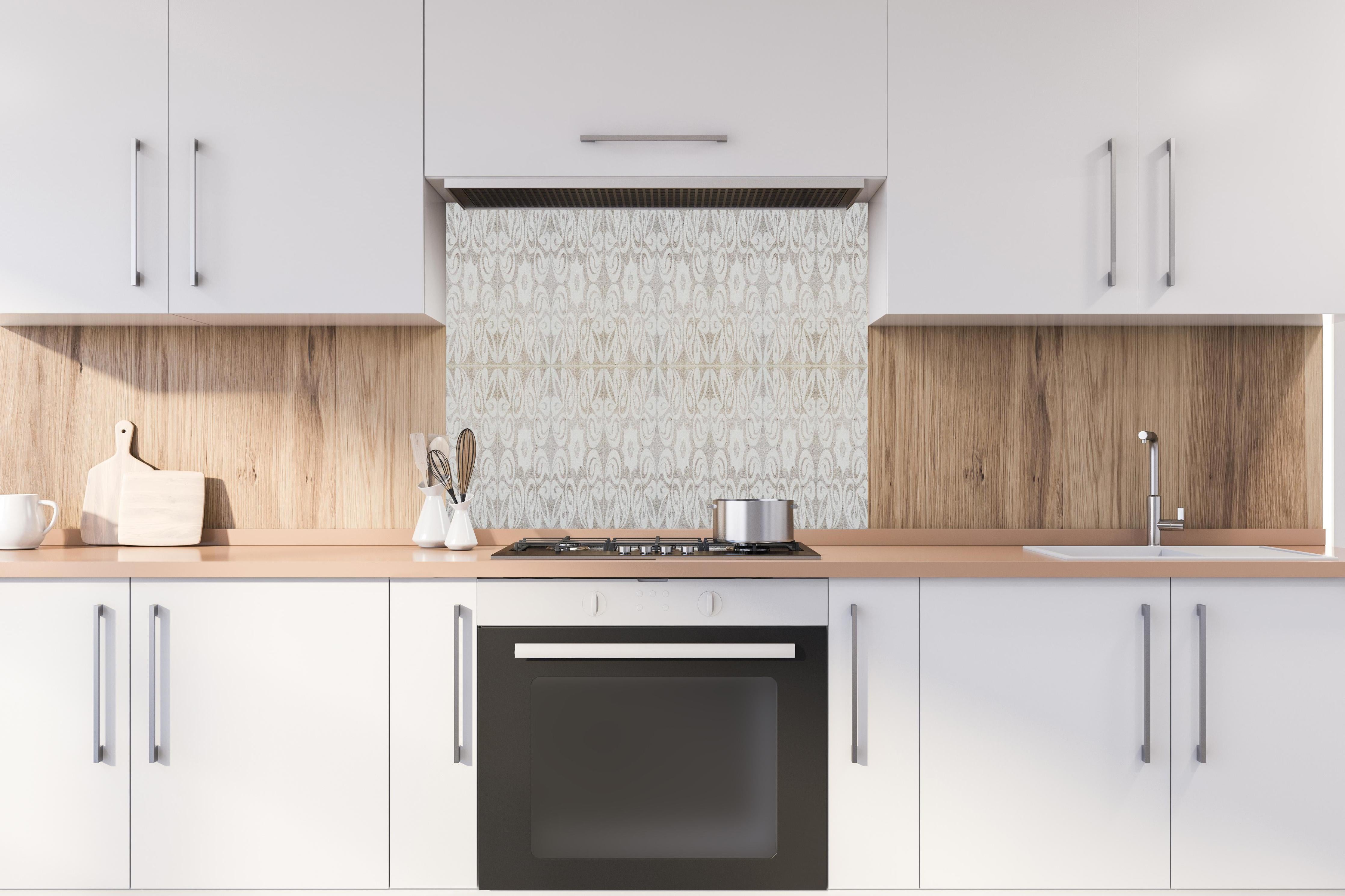 Spritzschutz - Beiges quadratisches Mosaikmotiv hinter einem Cerankochfeld zwischen Holz-Kochutensilien
