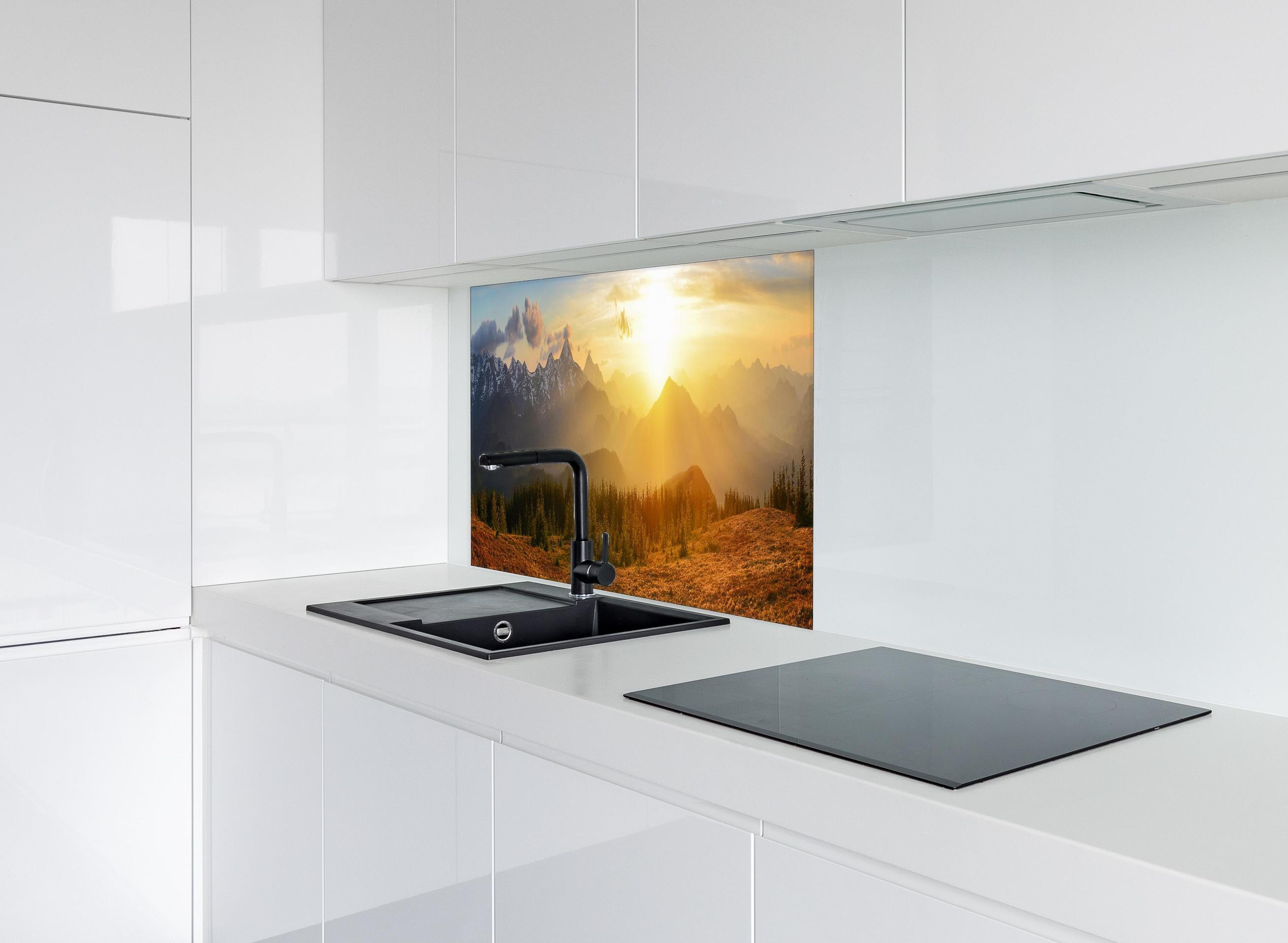 Spritzschutz - Berge im Sonnenuntergang hinter einem Cerankochfeld zwischen Holz-Kochutensilien
