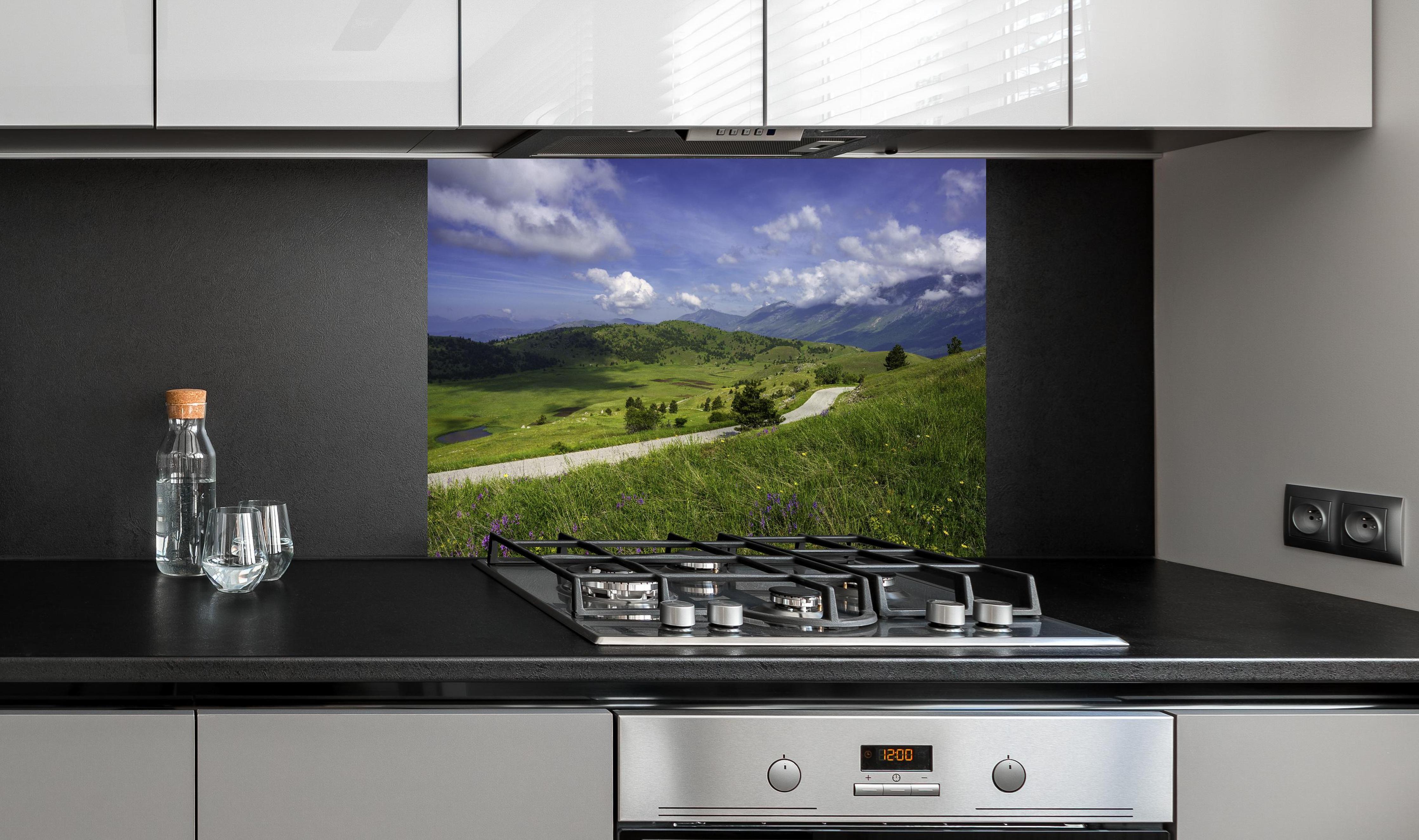 Spritzschutz - Berglandschaft - Berglandschaft - Naturpark Gran Sasso hinter einem Cerankochfeld zwischen Holz-Kochutensilien

