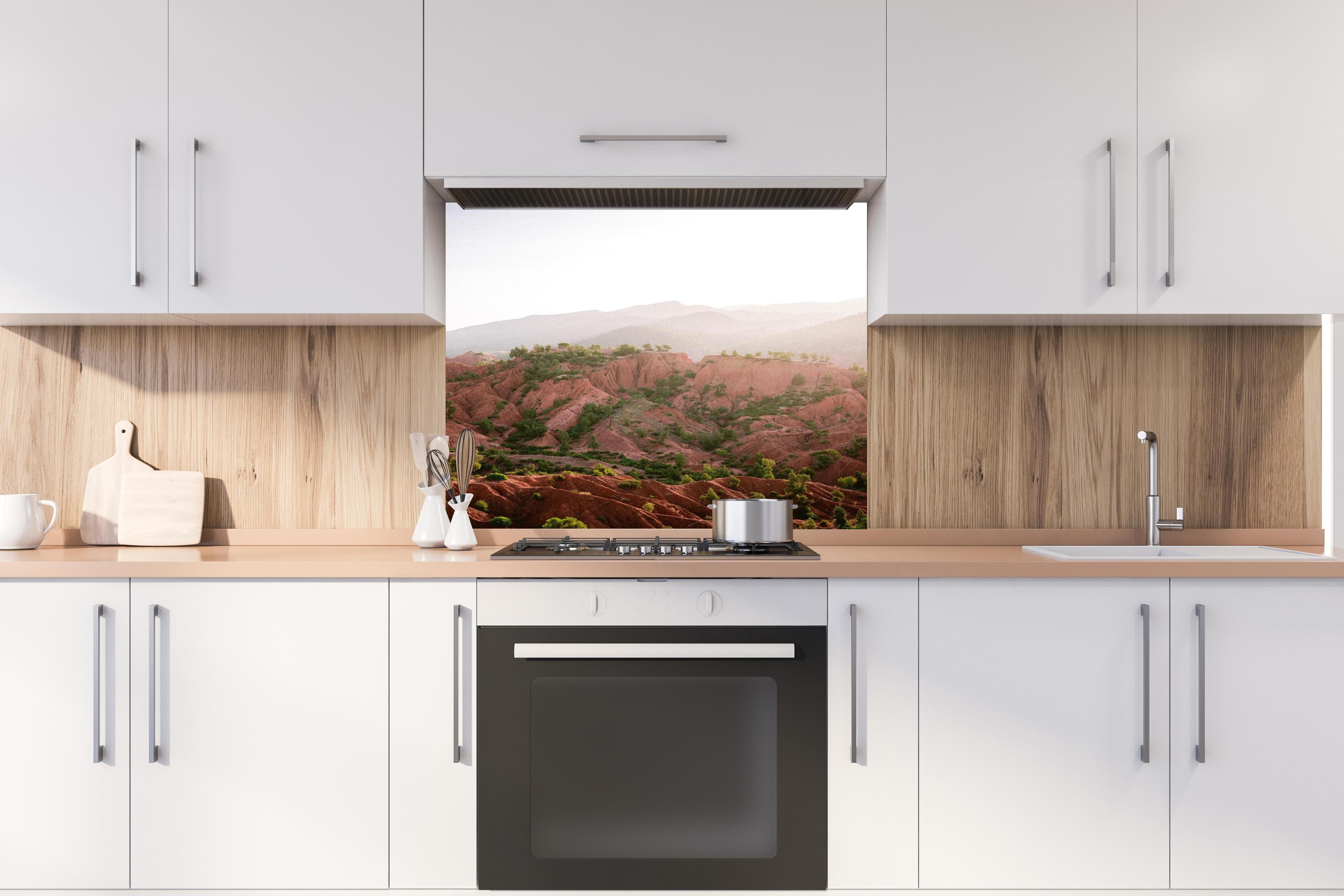 Spritzschutz - Berglandschaft im Ourika-Tal bei Sonnenaufgang hinter einem Cerankochfeld zwischen Holz-Kochutensilien
