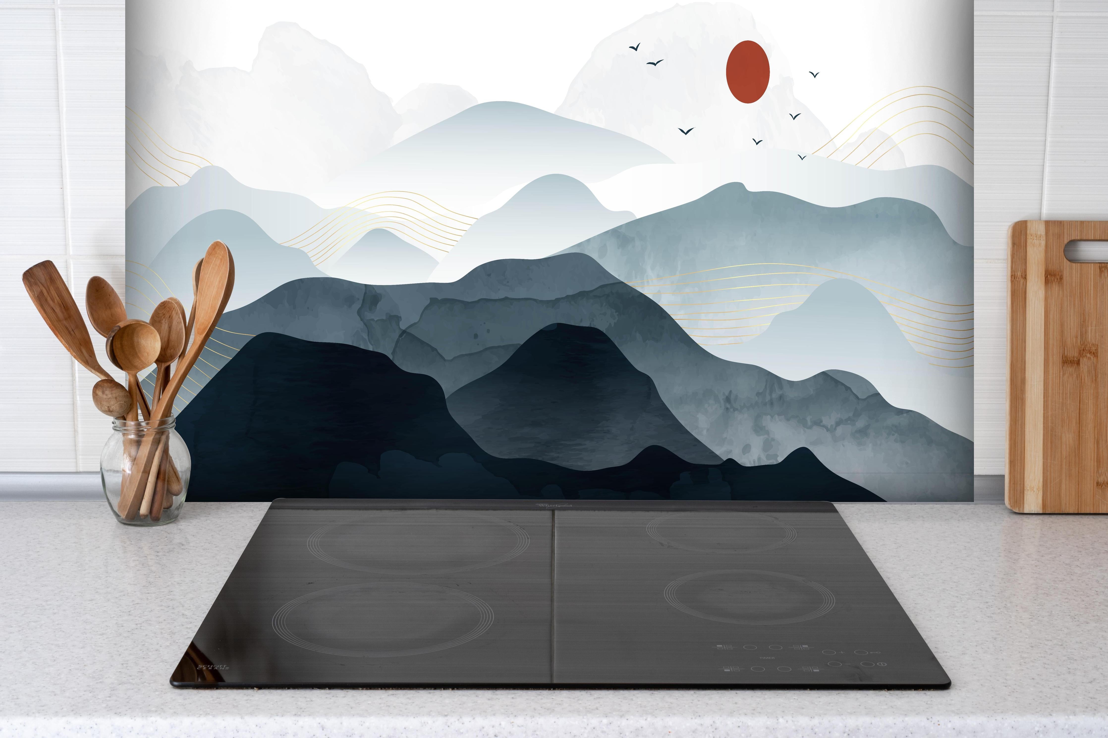 Spritzschutz - Bergpanorama mit rotem Sonnenkreis Kunst hinter einem Cerankochfeld zwischen Holz-Kochutensilien
