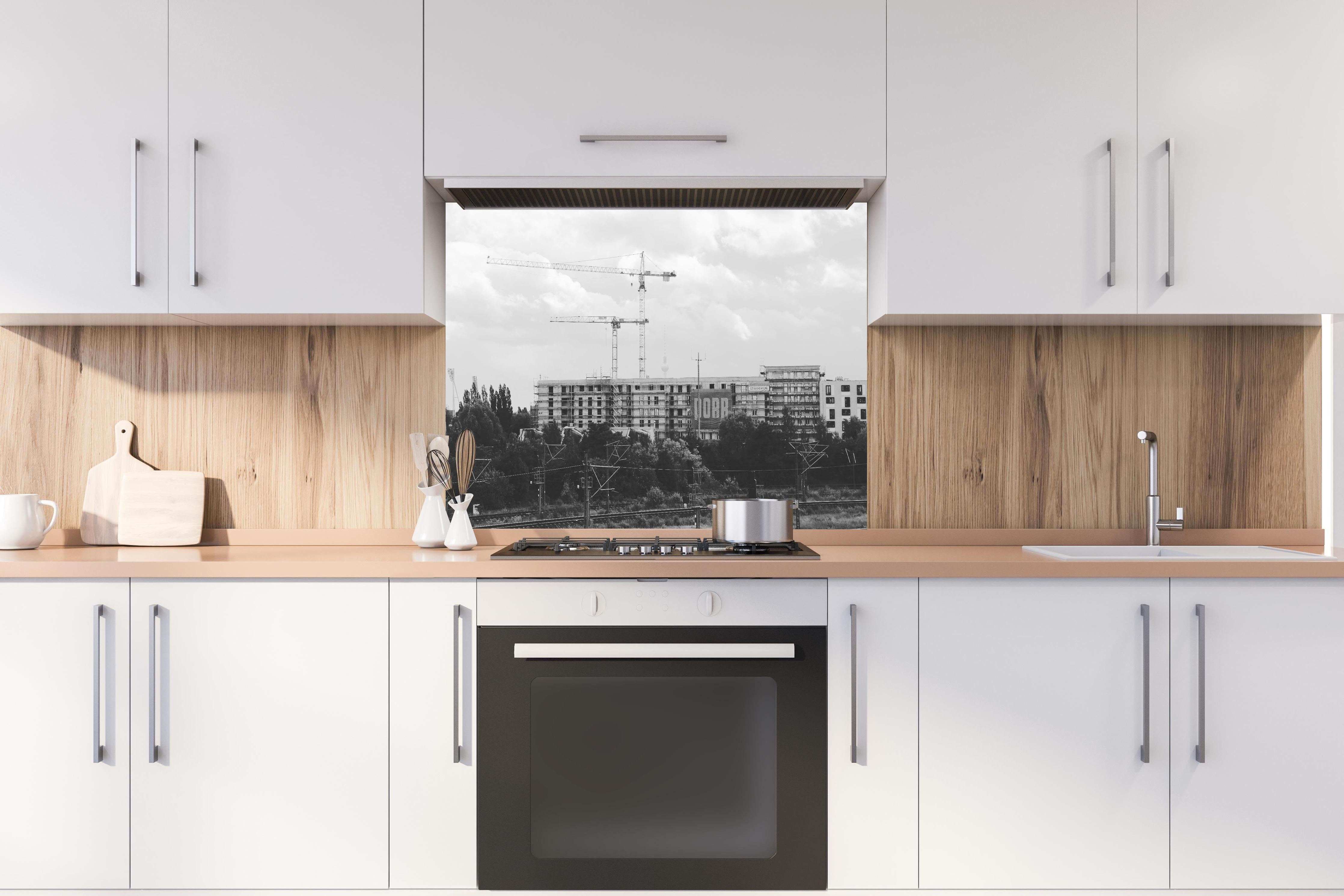 Spritzschutz - Berlin B&W Urban Construction Skyline hinter einem Cerankochfeld zwischen Holz-Kochutensilien
