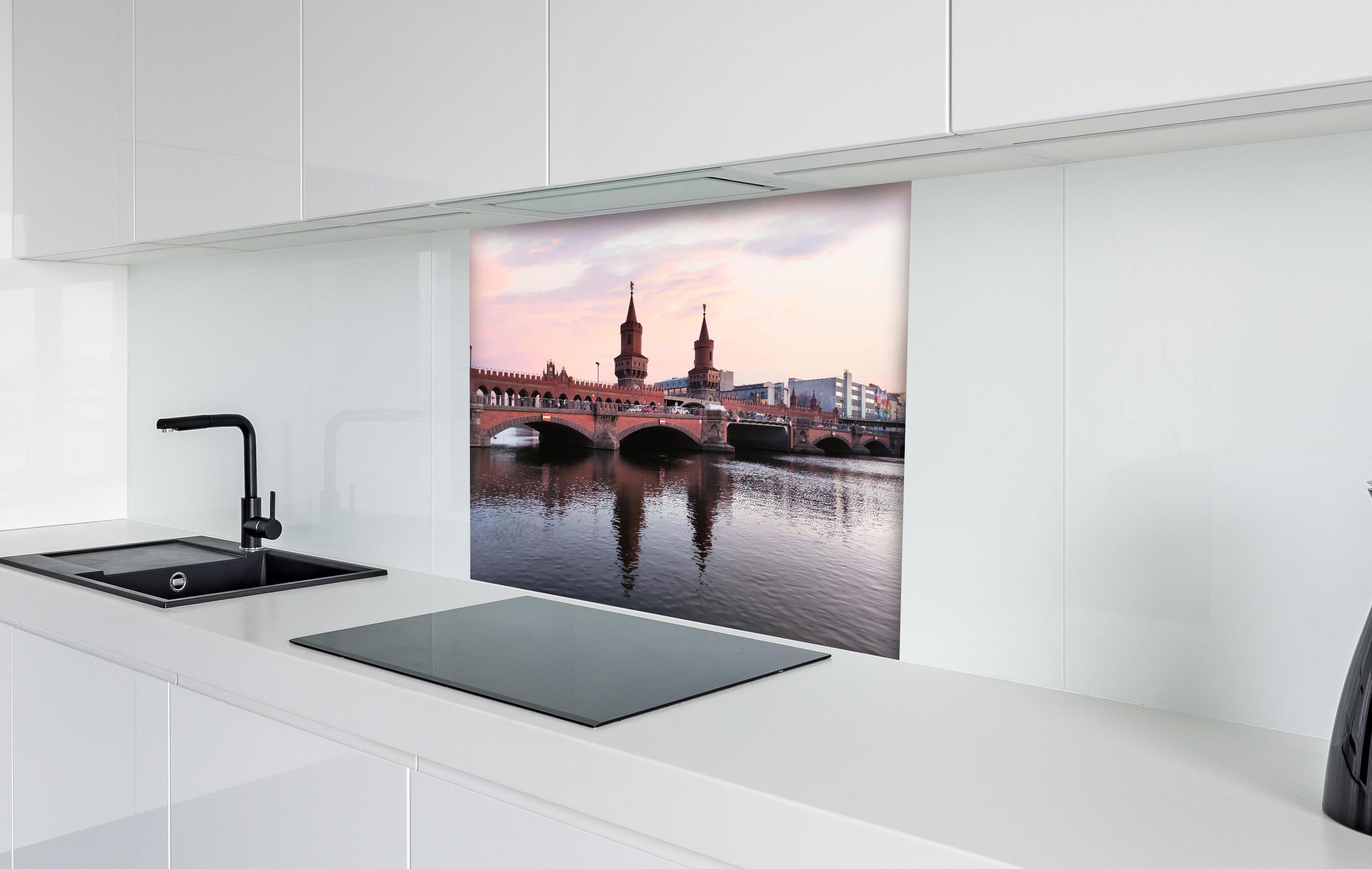 Spritzschutz - Berliner Brücke bei Tag hinter einem Cerankochfeld zwischen Holz-Kochutensilien
