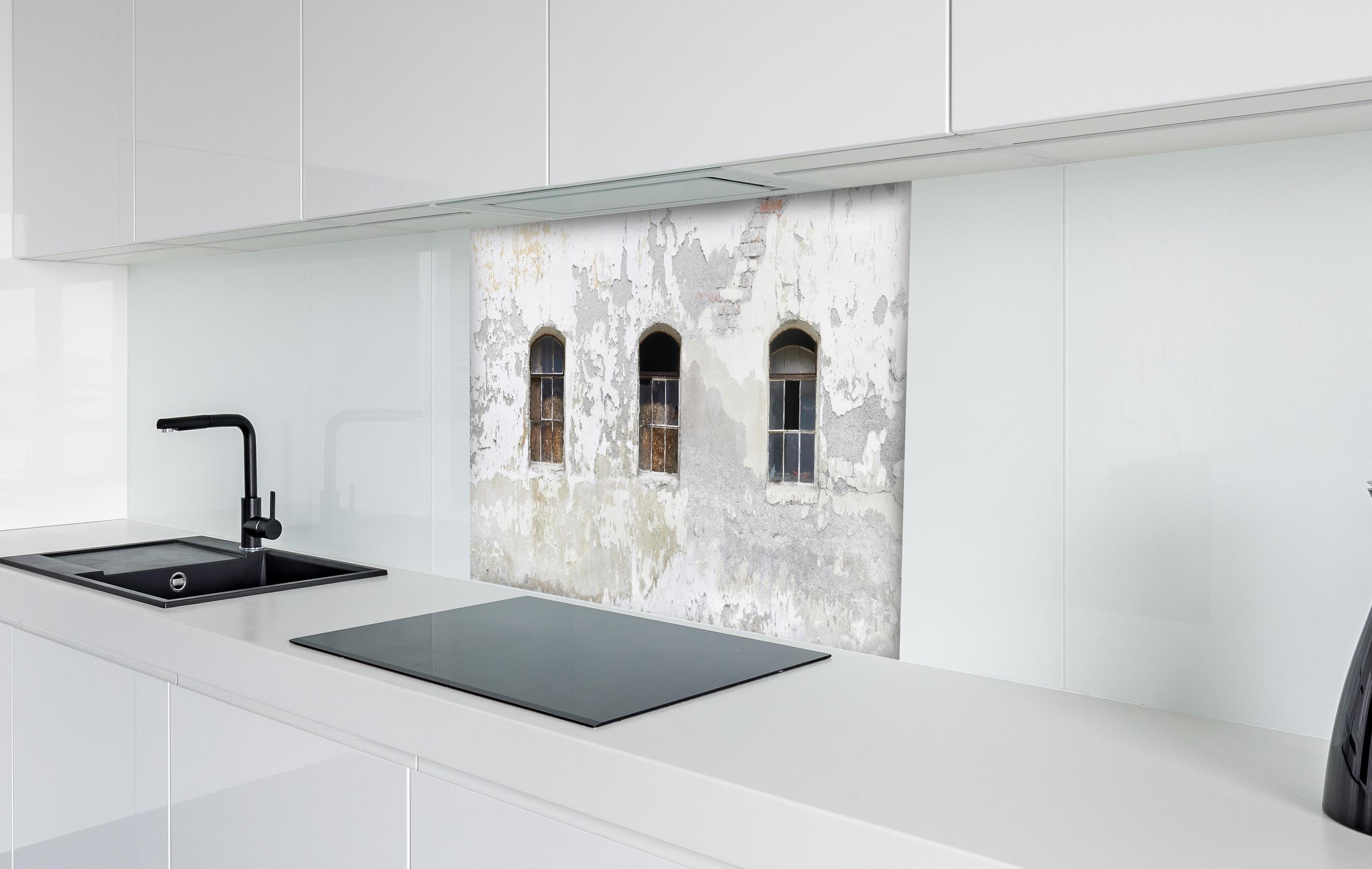 Spritzschutz - Beschädigte Fenster einer veralteten Hauswand hinter einem Cerankochfeld zwischen Holz-Kochutensilien
