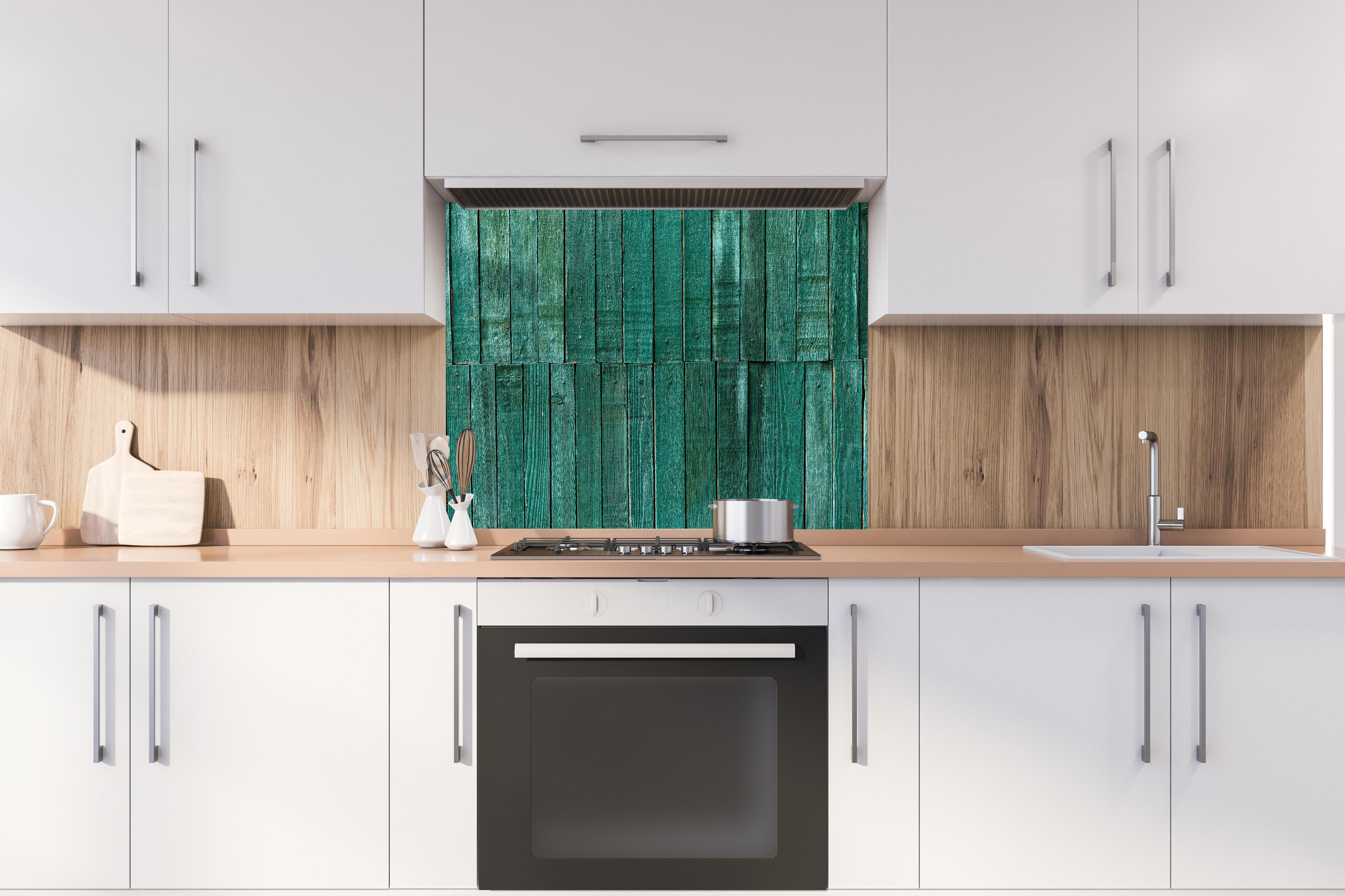 Spritzschutz - Bläuliche Holzbretter hinter einem Cerankochfeld zwischen Holz-Kochutensilien
