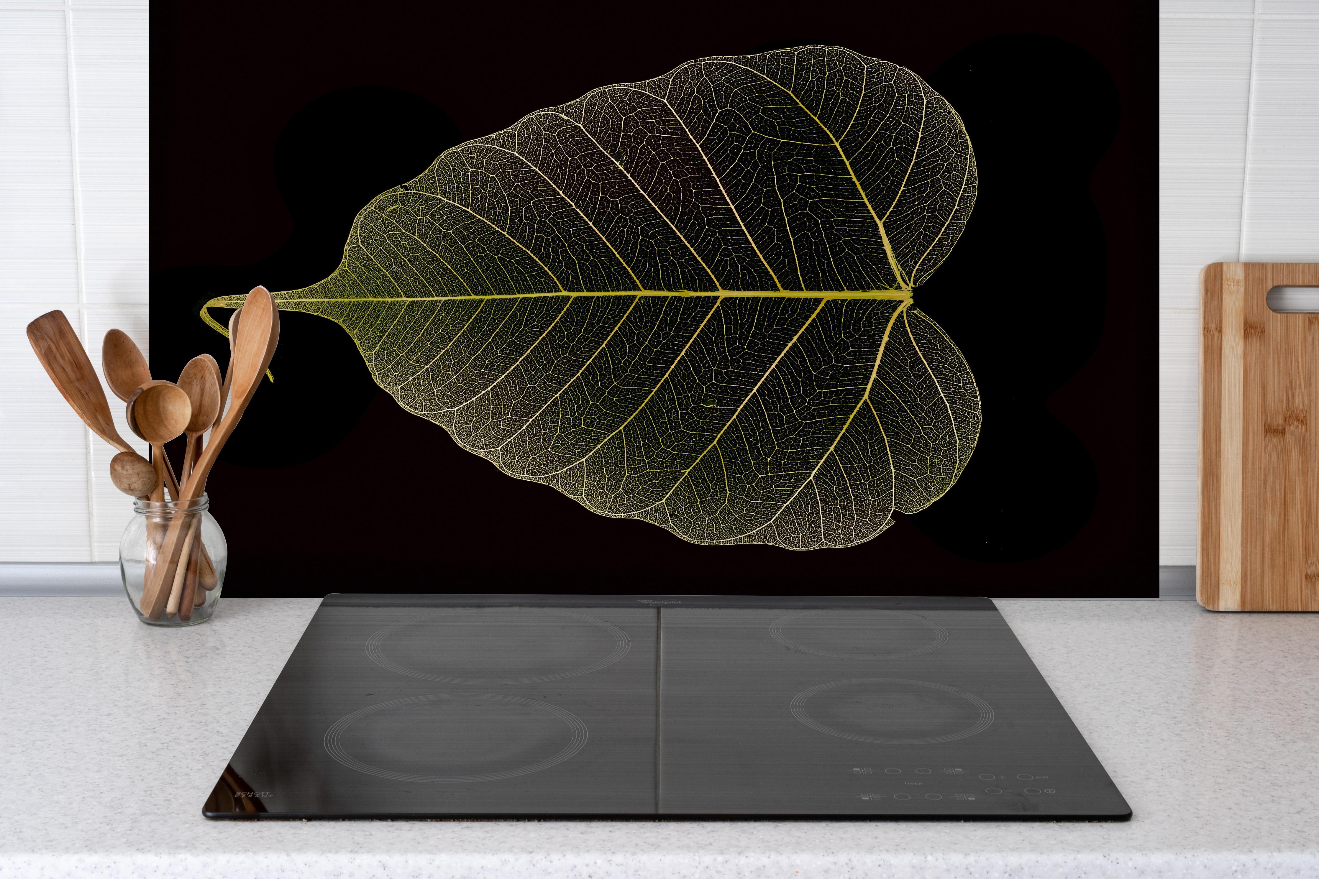 Spritzschutz - Blattadern Makromuster Gelb Detail hinter einem Cerankochfeld zwischen Holz-Kochutensilien
