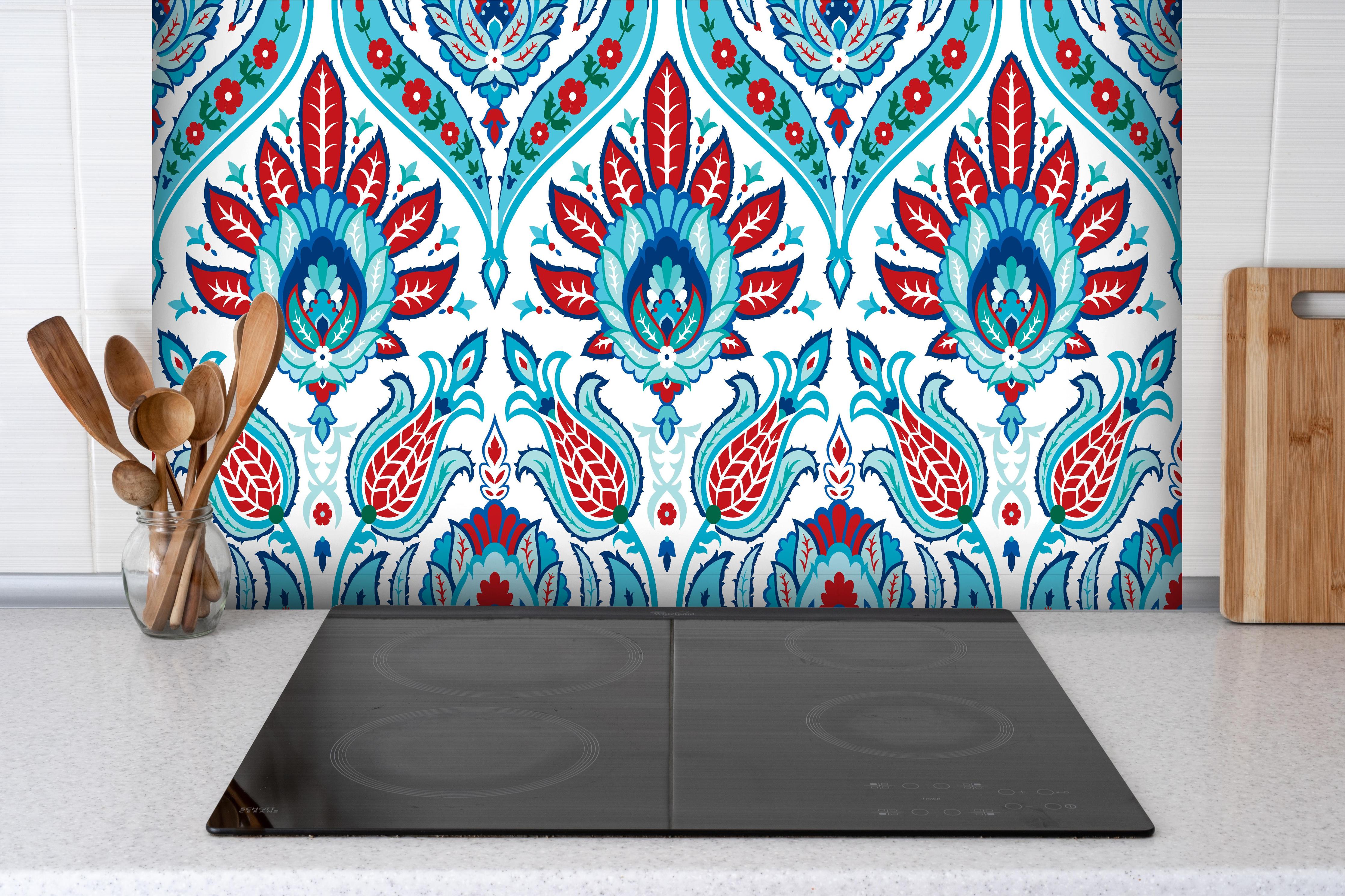 Spritzschutz - Blau-Roter Exotischer Blumendruck hinter einem Cerankochfeld zwischen Holz-Kochutensilien
