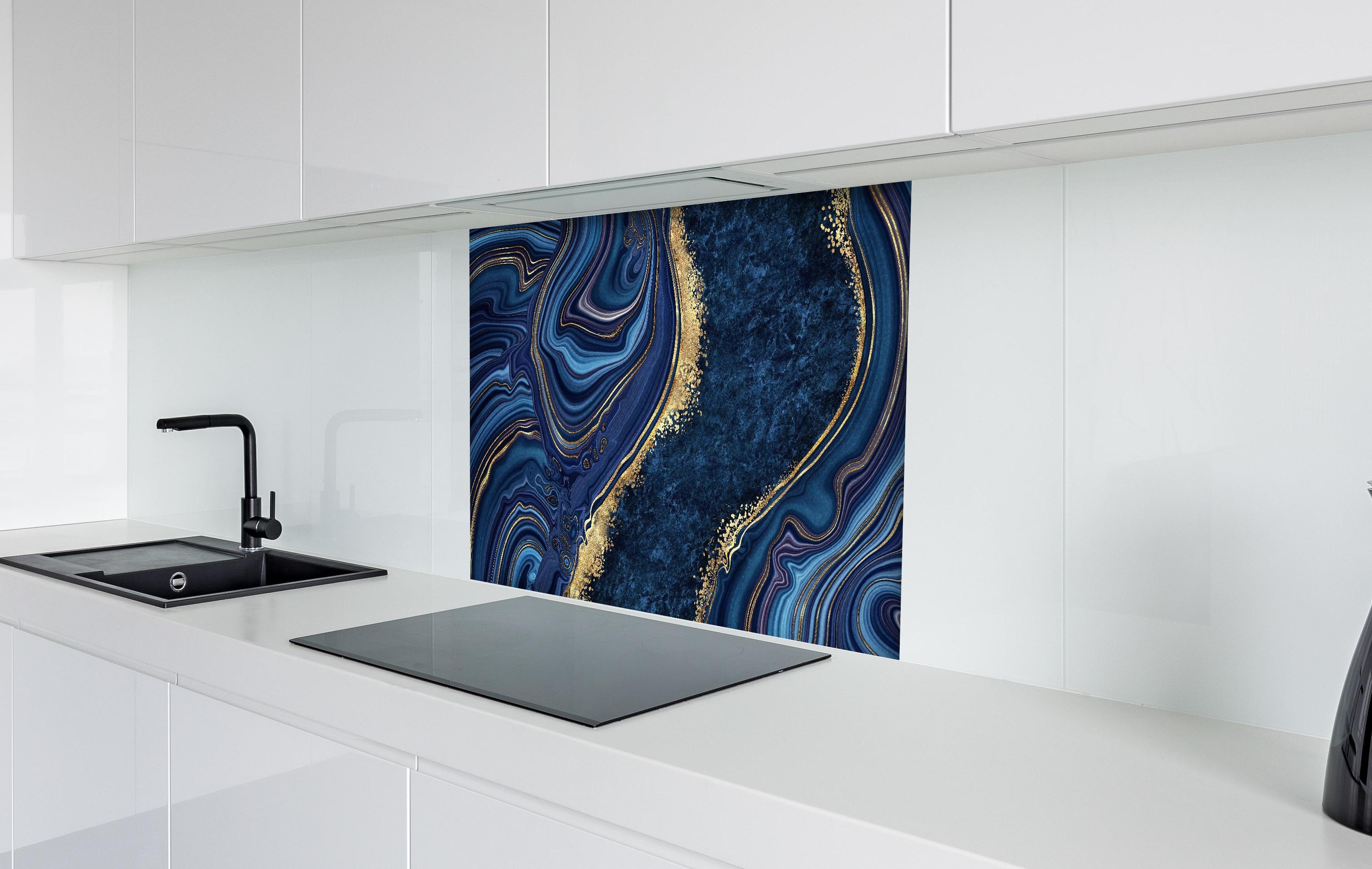 Spritzschutz - Blau goldenes Mosaik Design aus Marmor hinter einem Cerankochfeld zwischen Holz-Kochutensilien
