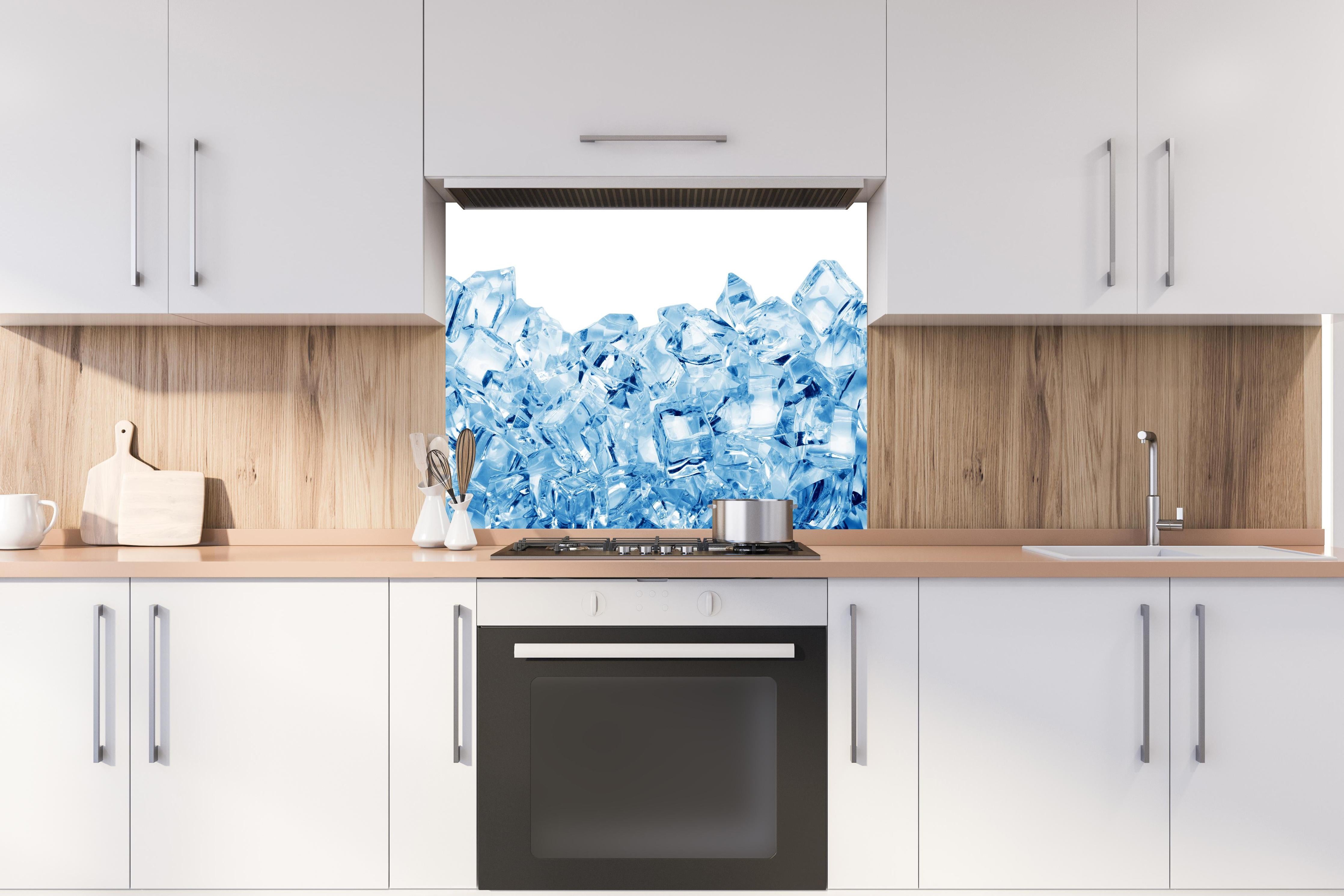 Spritzschutz - Blau kristallklarer Eiswürfel hinter einem Cerankochfeld zwischen Holz-Kochutensilien
