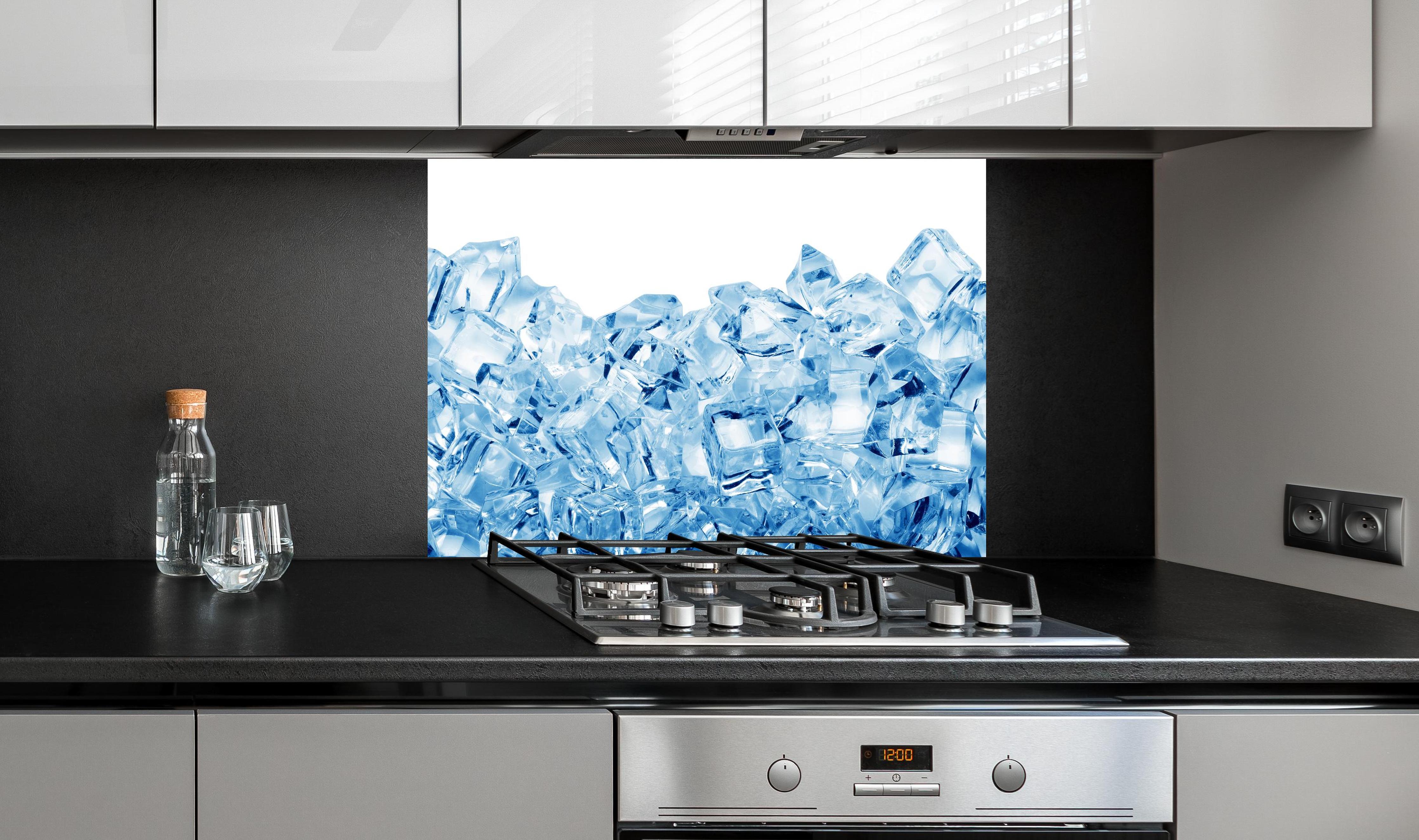 Spritzschutz - Blau kristallklarer Eiswürfel hinter einem Cerankochfeld zwischen Holz-Kochutensilien
