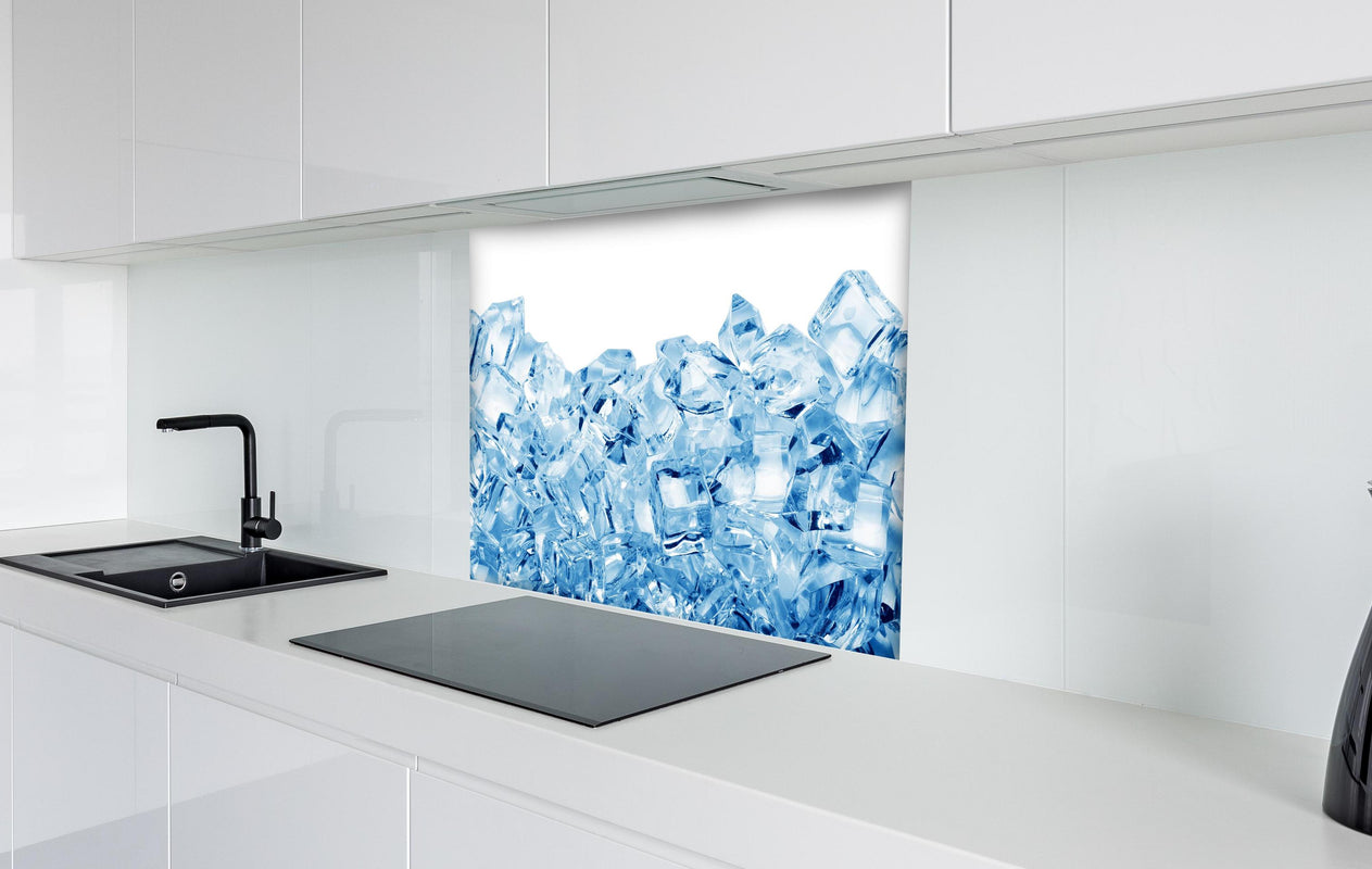 Spritzschutz - Blau kristallklarer Eiswürfel hinter einem Cerankochfeld zwischen Holz-Kochutensilien
