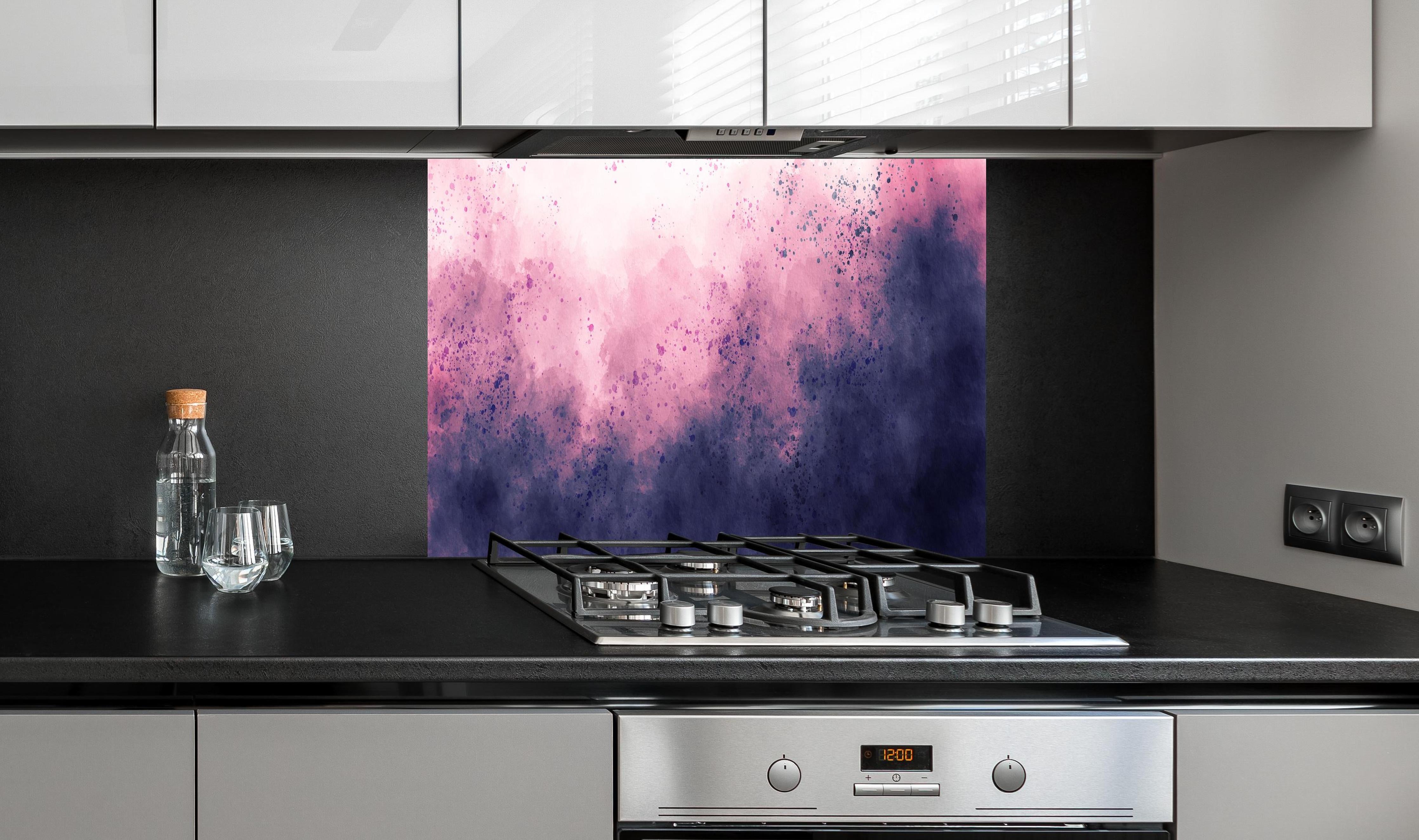 Spritzschutz - Blaulila Aquarellwolken Hintergrund hinter einem Cerankochfeld zwischen Holz-Kochutensilien
